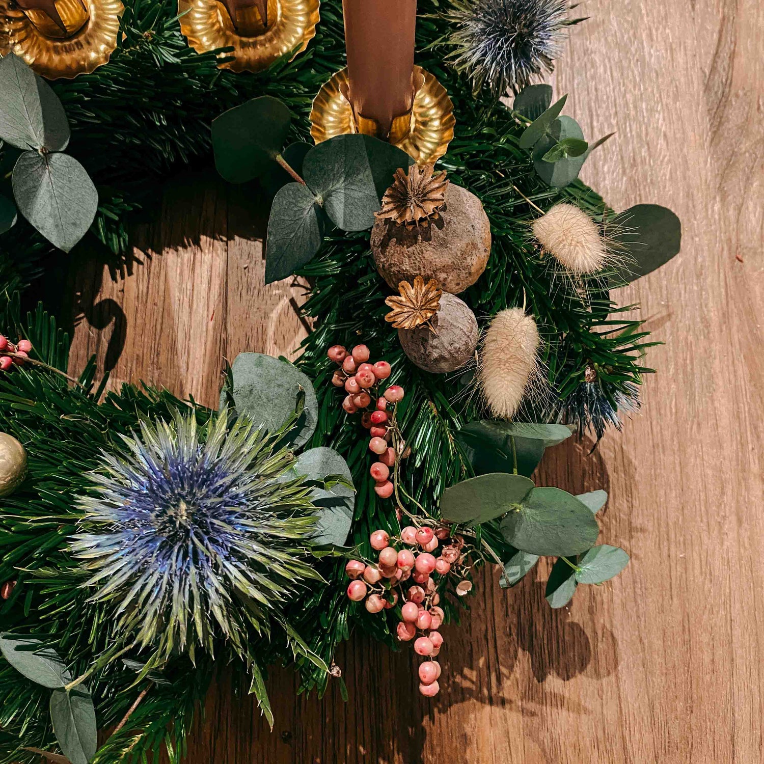 Nahaufnahme vom Adventskranz mit blauer Blume und rosa Beeren – Aschenputtel DIY Box Design.