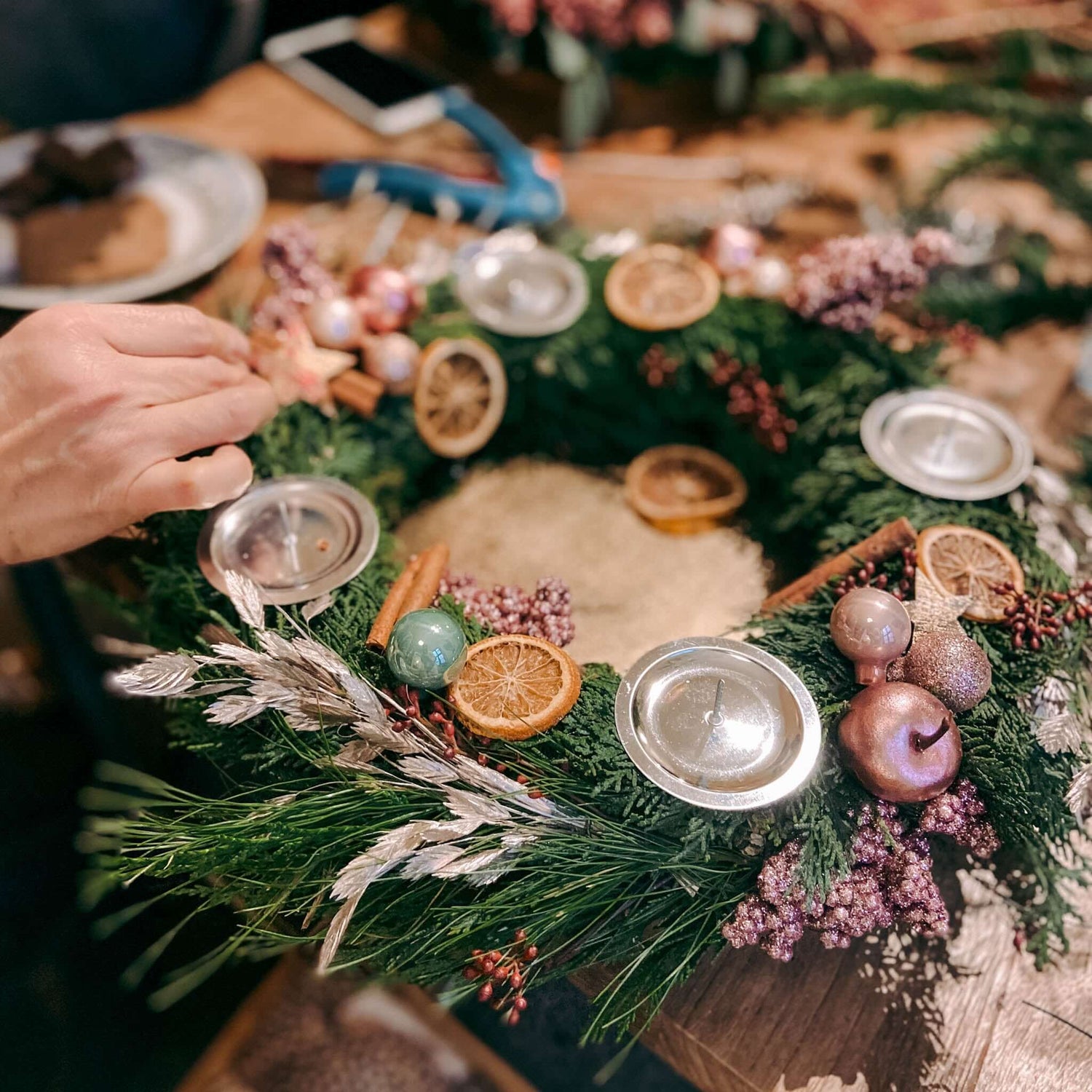 Teilnehmer erstellen ihren selbstgemachten adventskranz modern mit Dekoideen.Auch als Firmenevent buchbar.