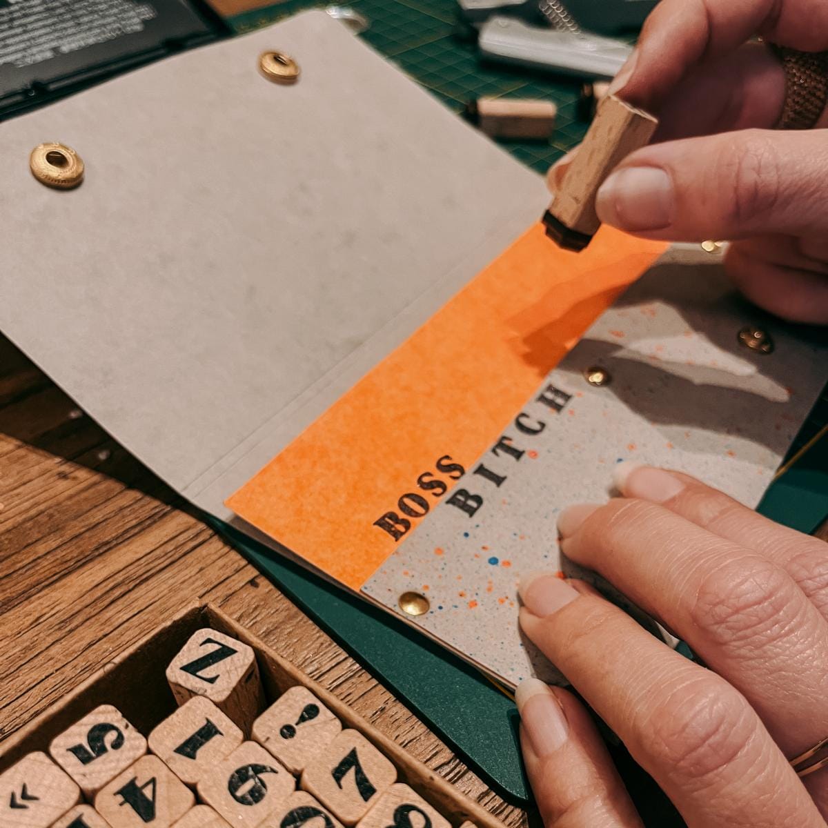 Hand stempelt Buchstaben auf veganes Leder-Portemonnaie, kreativer DIY Workshop bei Grimms Garten Berlin
