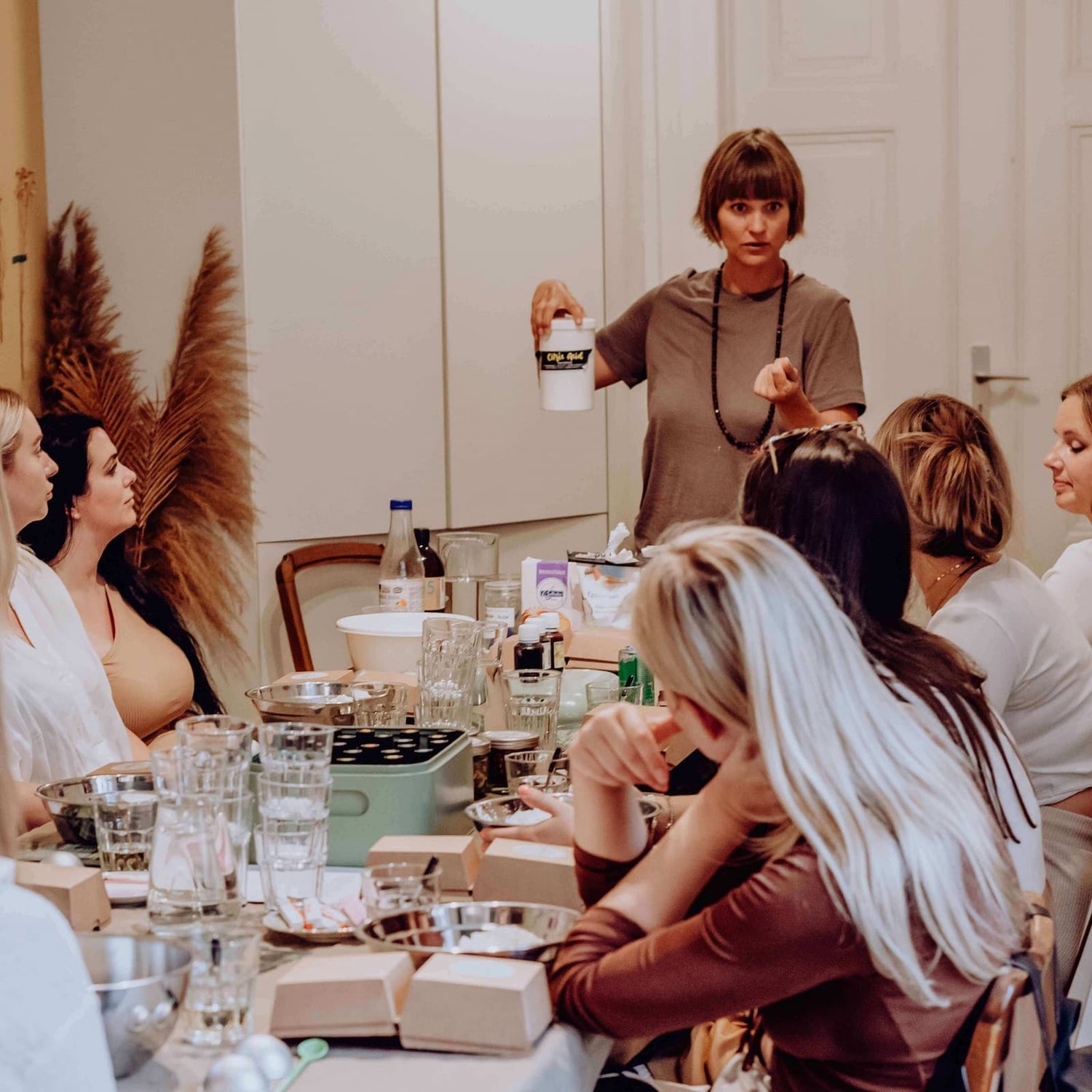 Kursleiterin erklärt Teilnehmerinnen die Herstellung von Badekugeln – Badekugel, Aromatherapie, DIY Workshop.