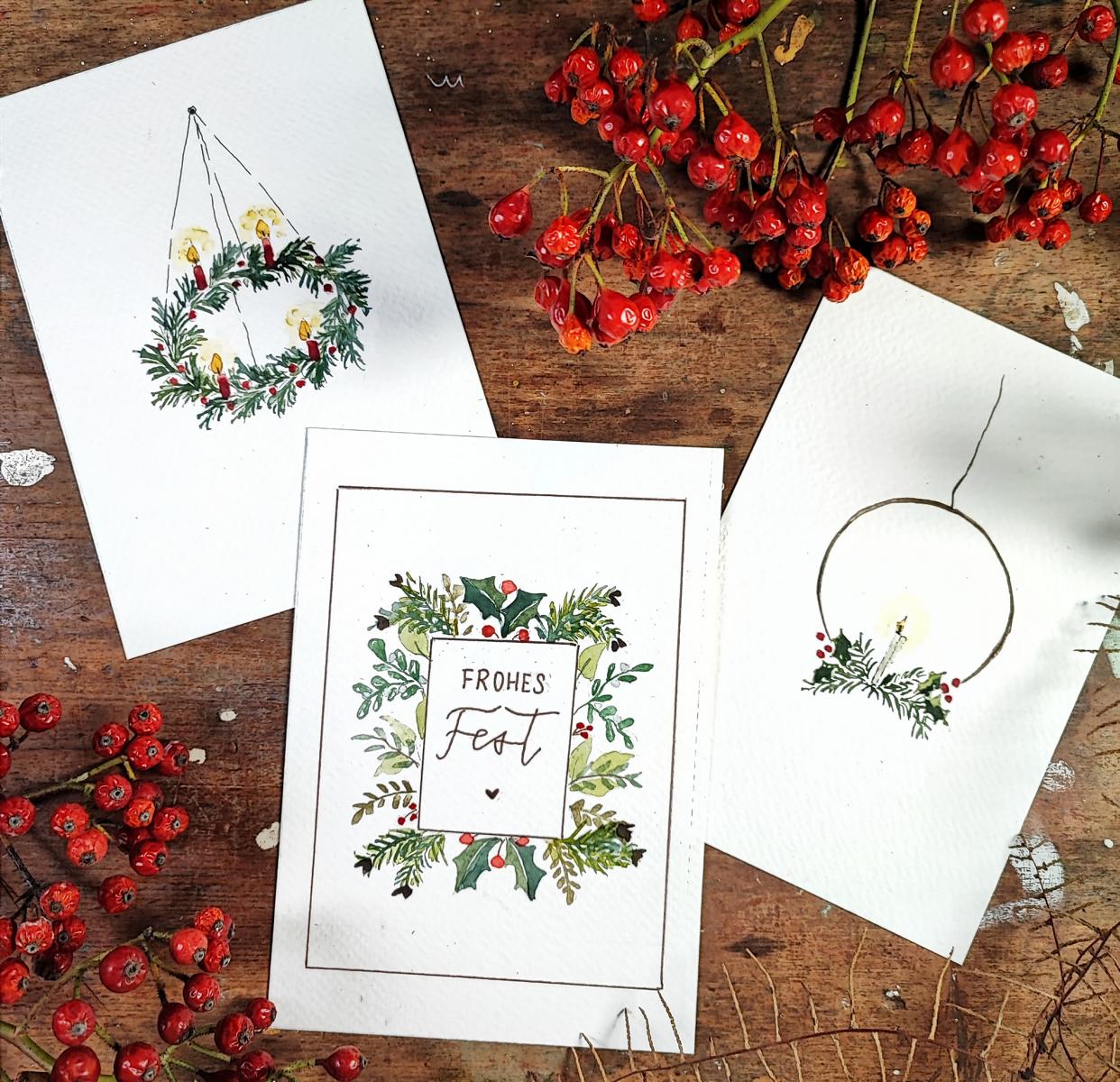Drei Weihnachtskarten auf Holztisch mit Stiften – Aquarell, Watercolour, DIY Karten, auch für Firmenevents.