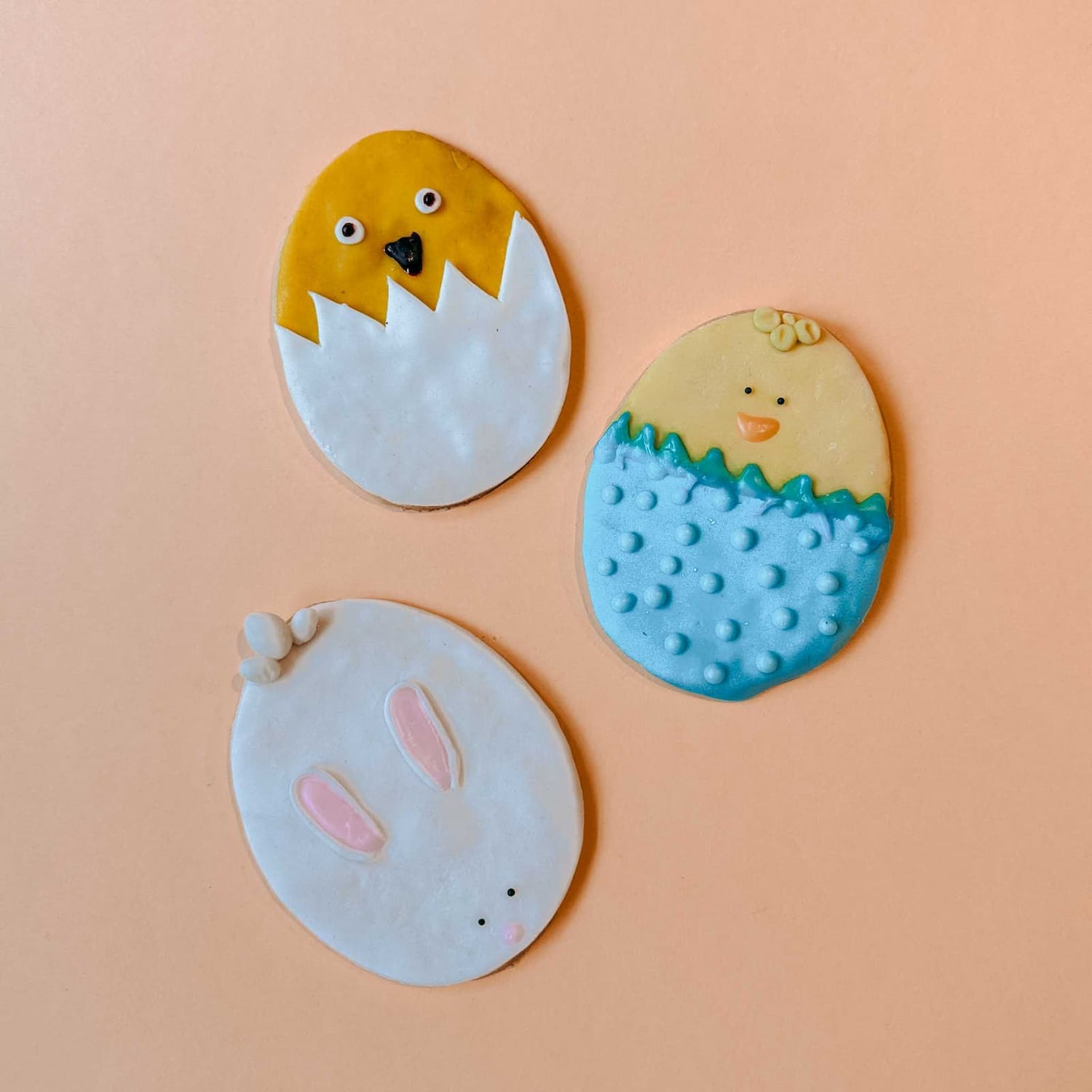 Drei fertig dekorierte Osterkekse mit zwei Küken in Eierschalen und einem Hasen beim Osterkekse Workshop von GRIMMS GARTEN, Kreativkurs in Berlin