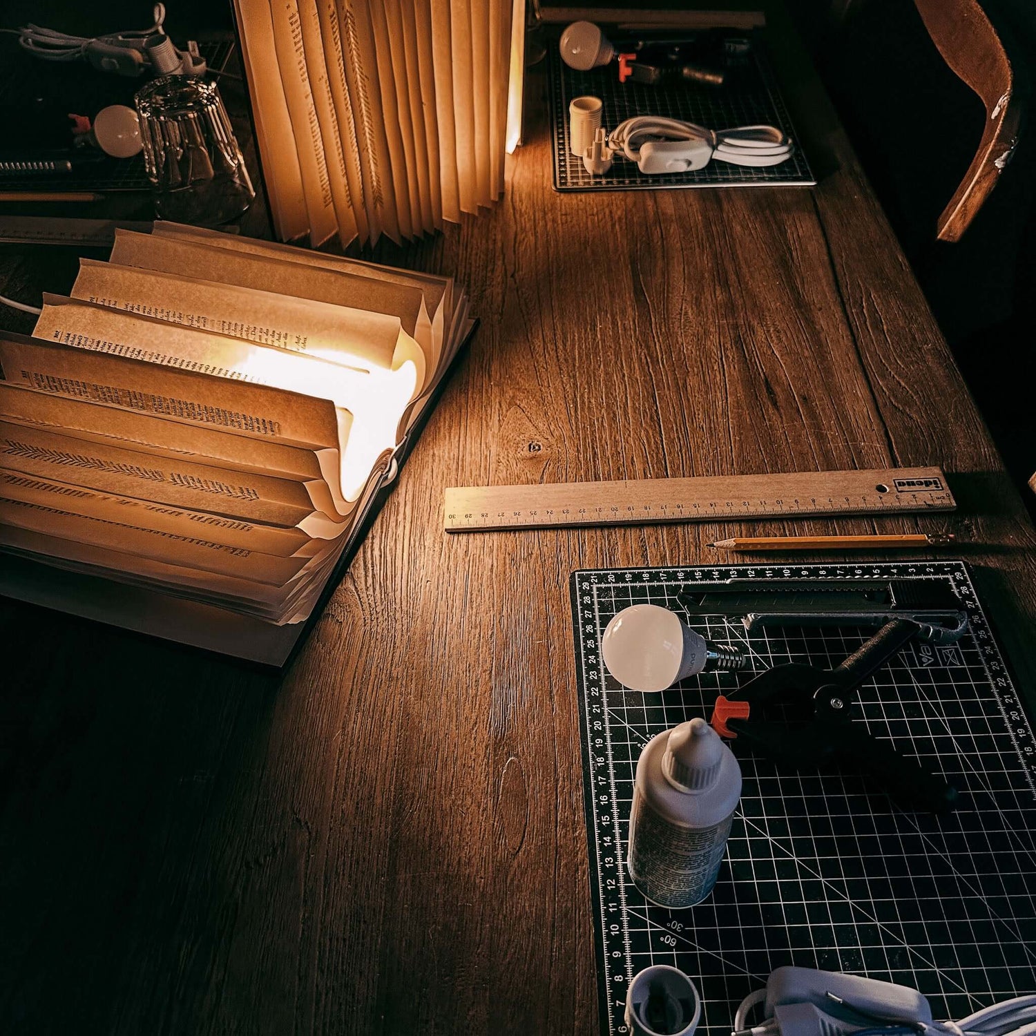 Zwei fertige Buchlampen auf Holztisch mit Arbeitsstation – buchlampe, upcycling workshop, kreative deko. Auch für Firmenevents.