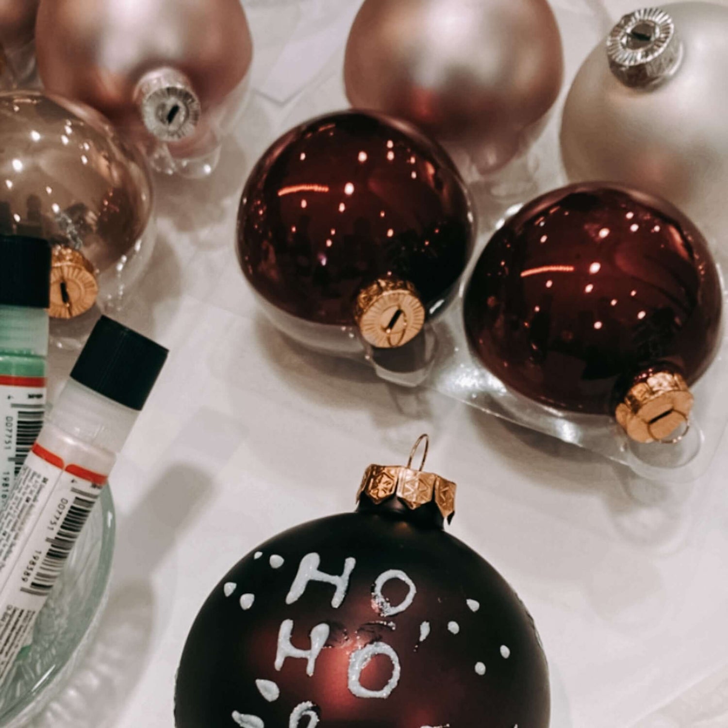 Dunkelrote Kugel mit Aufschrift „Ho Ho Ho“ im Vordergrund – Weihnachtskugeln Workshop.