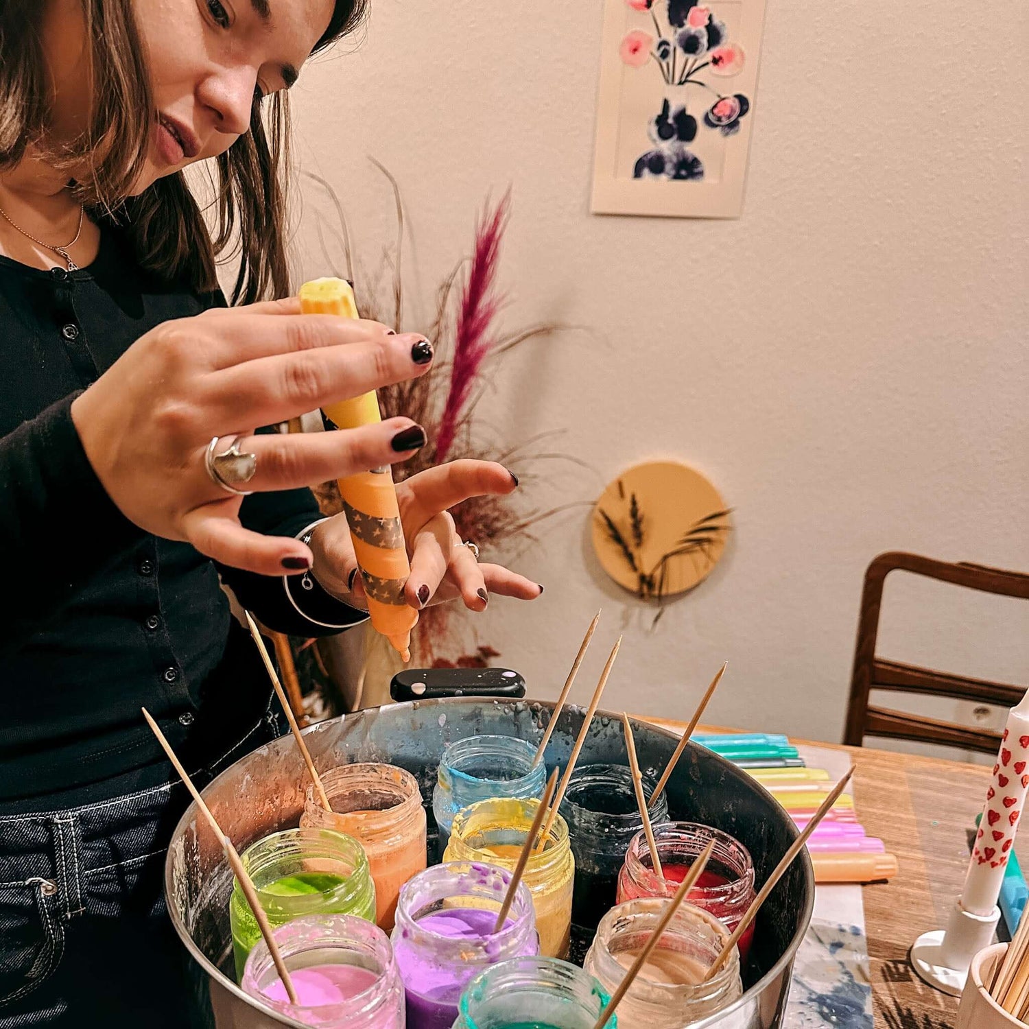 Frau betrachtet gedippte Kerze – bunte Kerzen selbst kreieren.