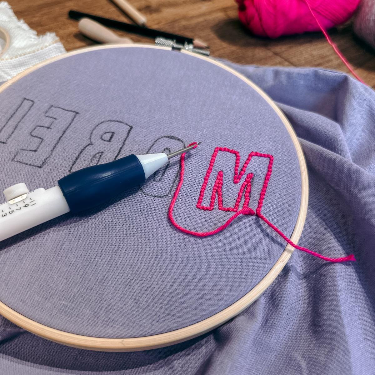 Lila T-Shirt im Rahmen mit pinker Punch-Needle – Punch-Needle Workshop Berlin, DIY Wohnaccessoires.