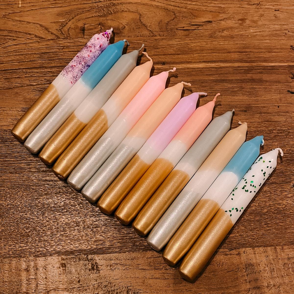 Viele Adventskerzen nebeneinander auf Tisch – dip dye adventskerzen, kerzen workshop berlin.Auch als Firmenevent buchbar.