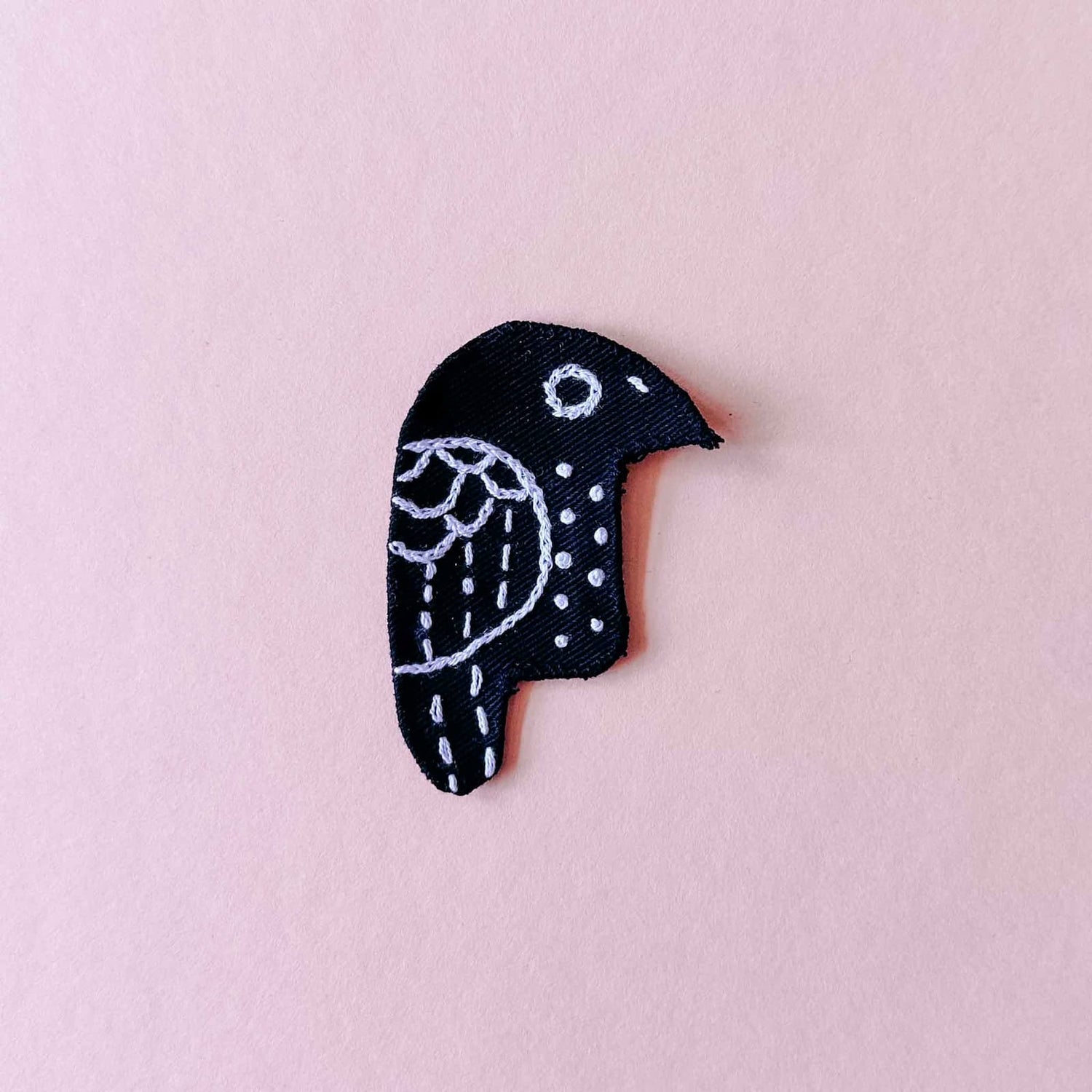Gestickter Vogel auf schwarzem Stoff mit weißer Naht als Patch beim Patches nähen Workshop von GRIMMS GARTEN, DIY Nähkurs in Berlin