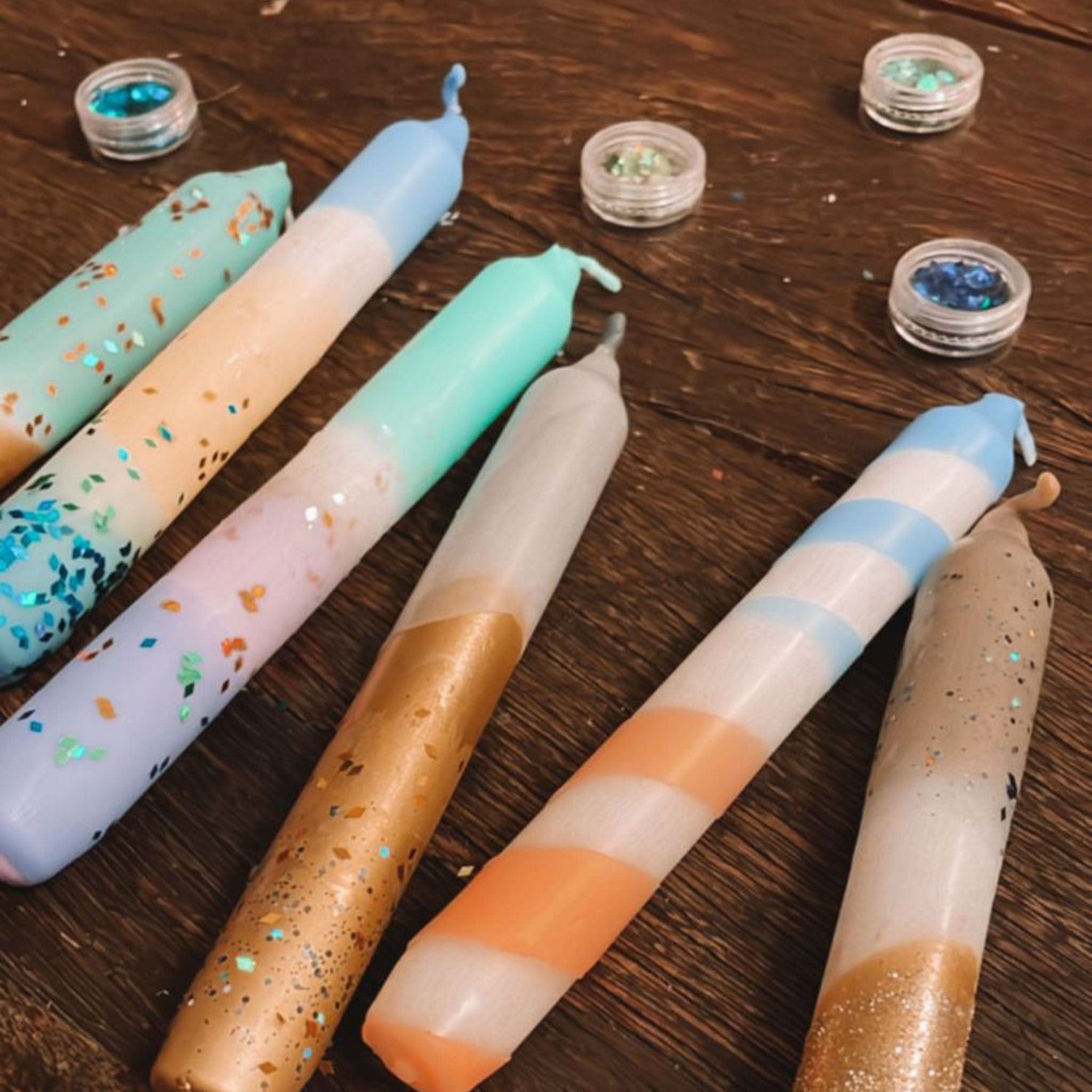 mehrere Kerzen nebeneinander auf Tisch – konfetti kerzen, glitzer kerzen, kerzen färben.Auch als Firmenevent buchbar.