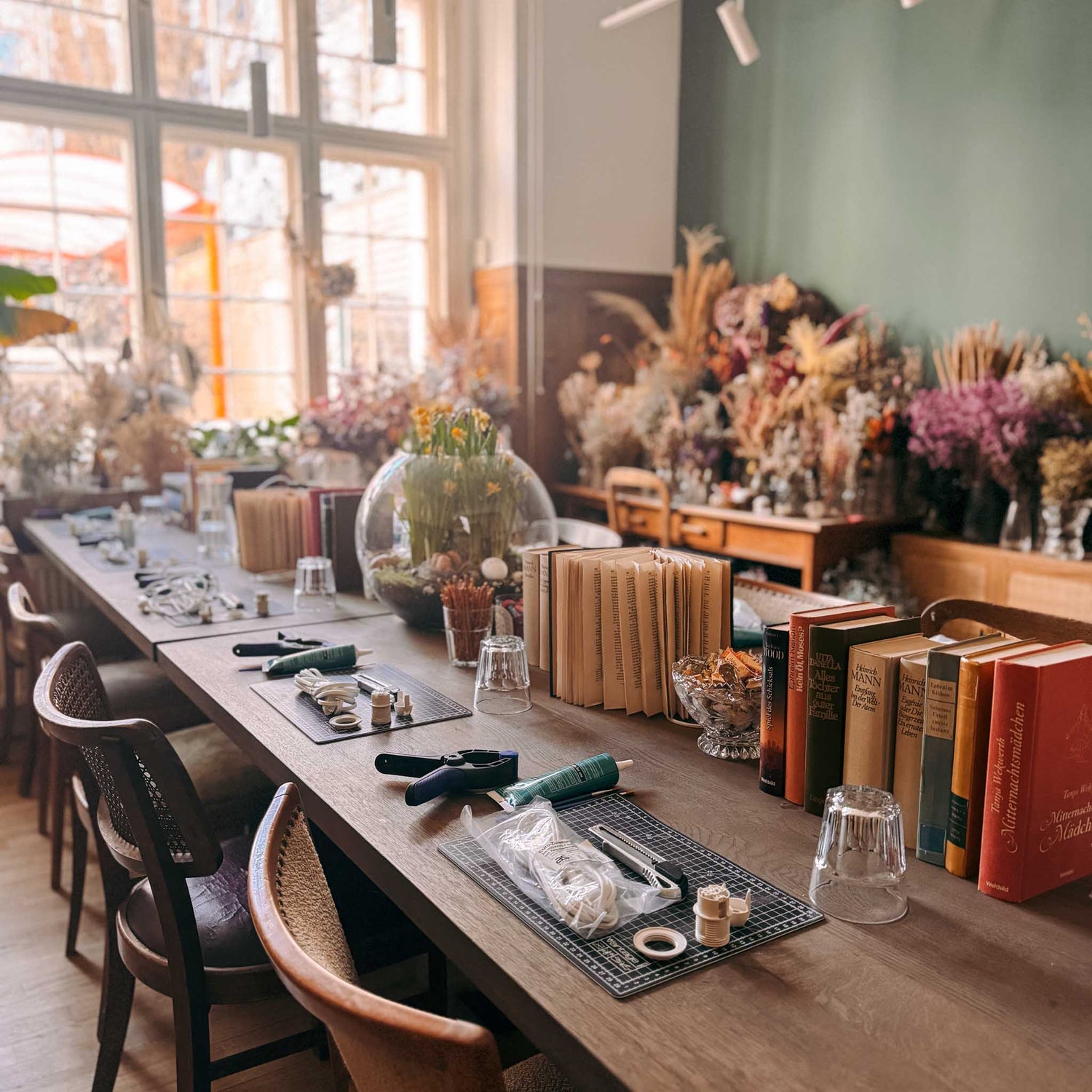 Tisch mit Materialien, Büchern und drei Arbeitsplätzen – upcycling workshop, buchlampe selber machen, diy lampe. Auch für Firmenevents.