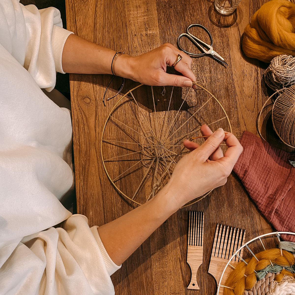 Hände gestalten Rundweben mit Materialien – DIY Webkurs für Boho Wanddeko in Berlin.