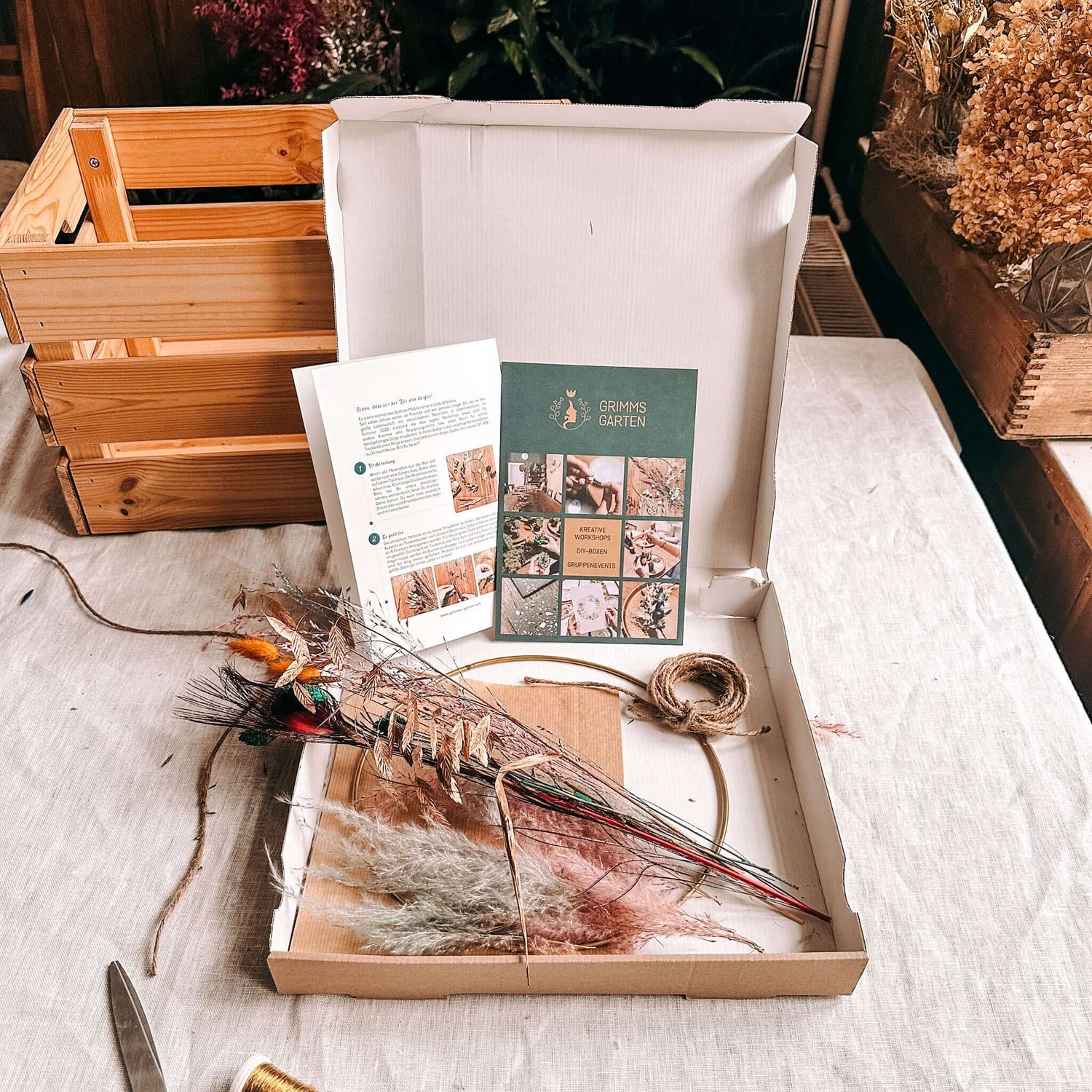 Offene DIY Box Pfauenauge mit Materialien für Trockenblumenring auf Tisch – Bastelset.