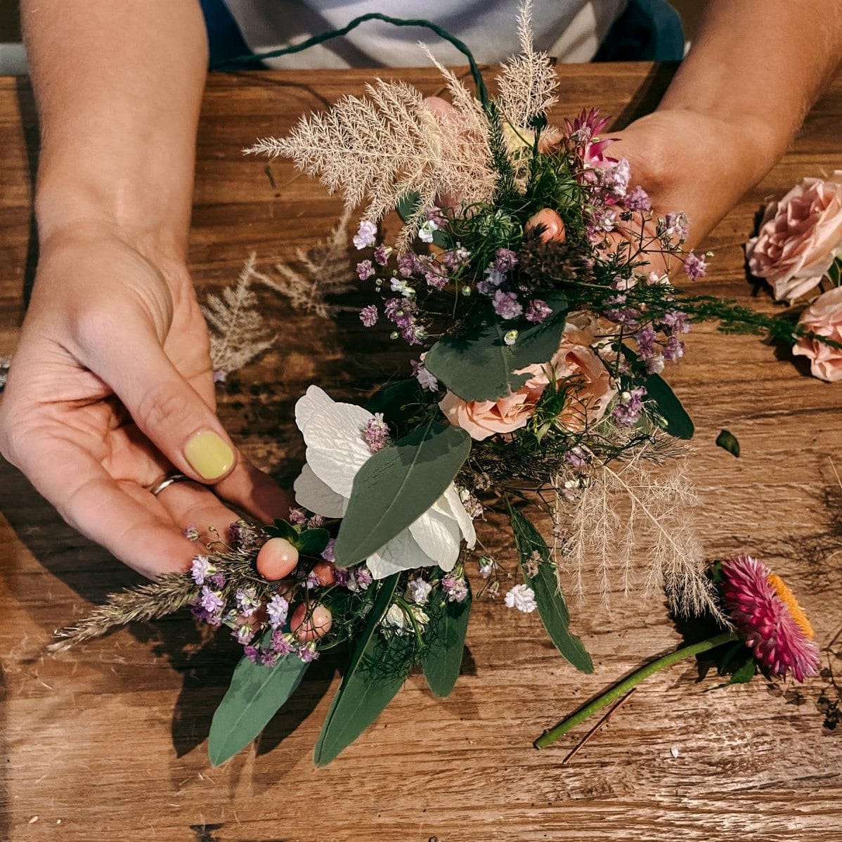 DIY Haarkranz in Rosa und Lila, in zwei Händen gehalten, kreativer Workshop bei Grimms Garten Berlin