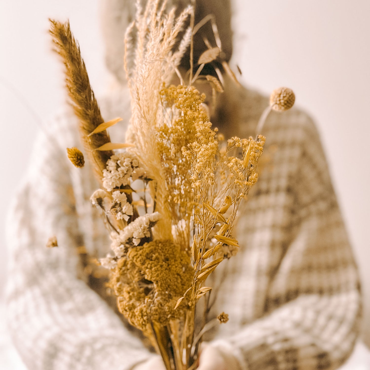 Frau hält gelb-weiß-beigen Blumenstrauß – natürliche Materialien aus der DIY Box Sonnenlicht.