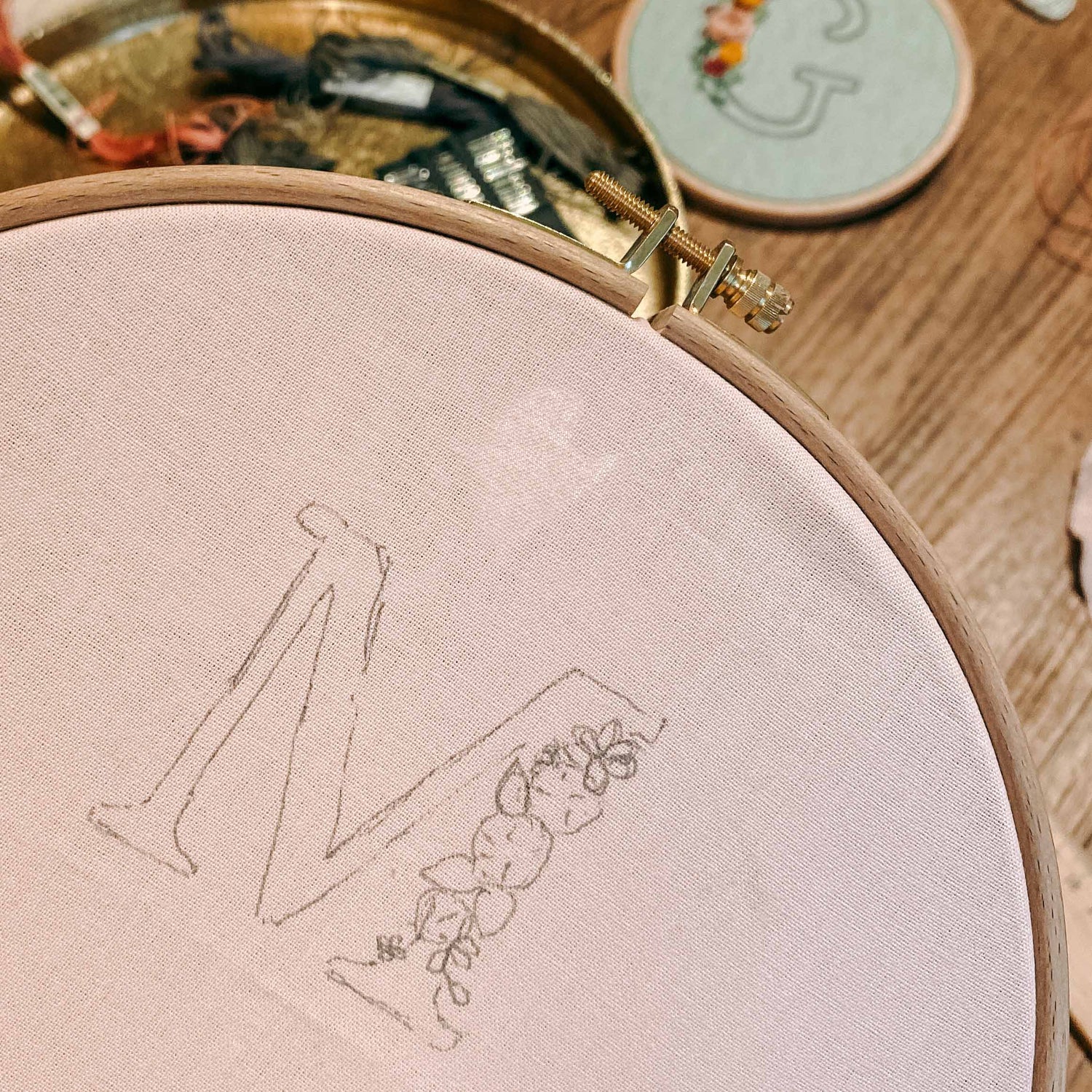 Aufgemalter Buchstabe M mit Blumen auf Stoffrahmen – Stickkurs, florales Monogramm