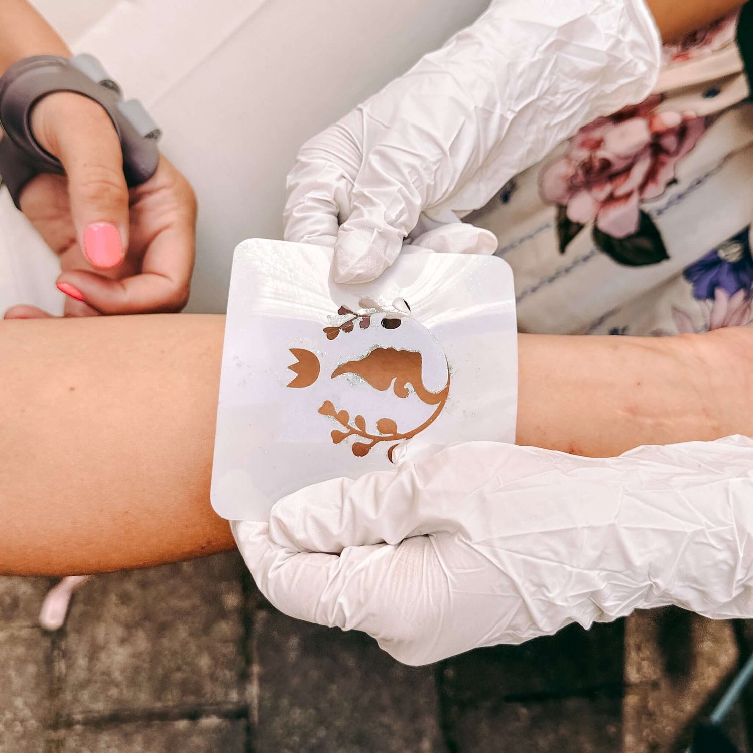 Zwei Hände legen Schablone auf Arm – Glitzertattoo Workshop für Firmenevent oder JGA.