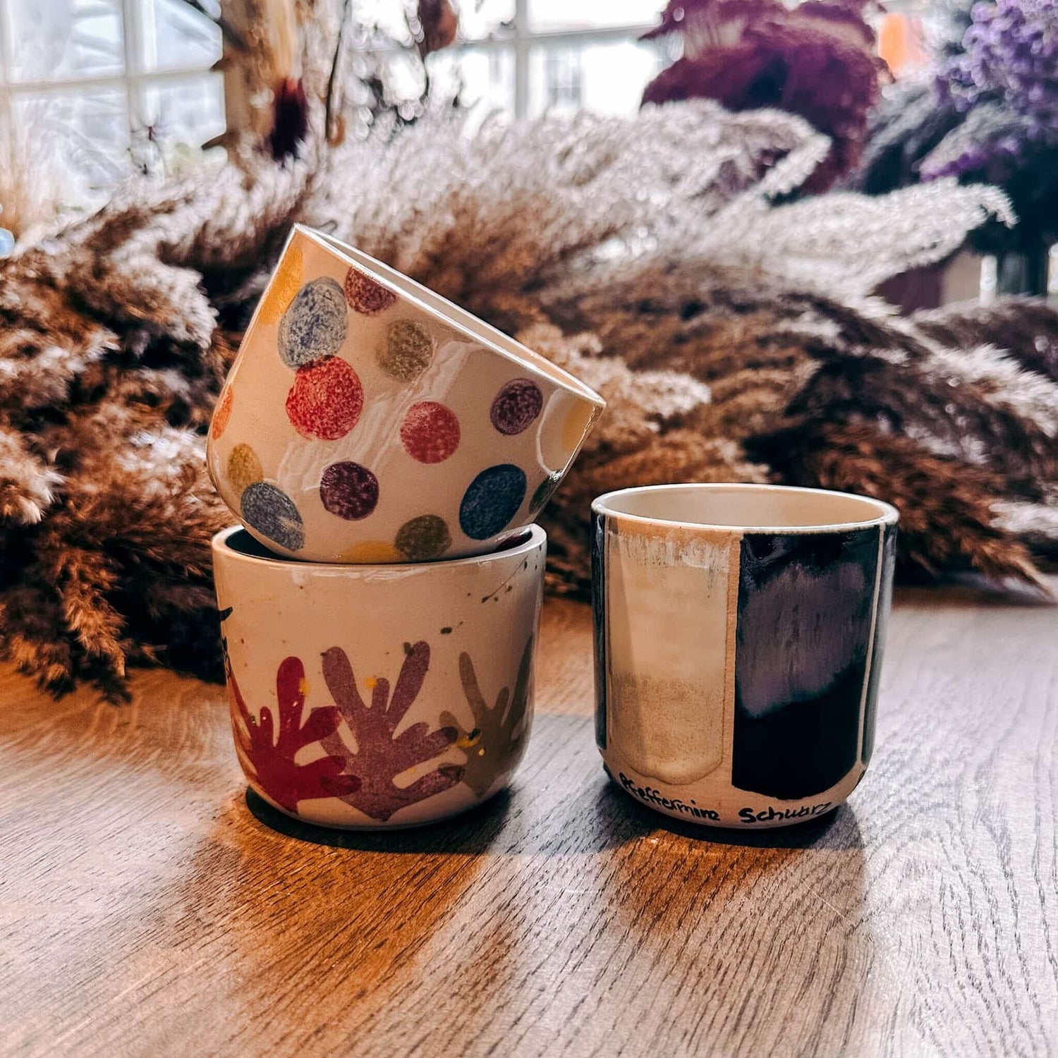 Fertig bemalte Keramik‑Tassen gestapelt auf Tisch – Keramik Workshop Berlin, individuelles Keramikhandwerk