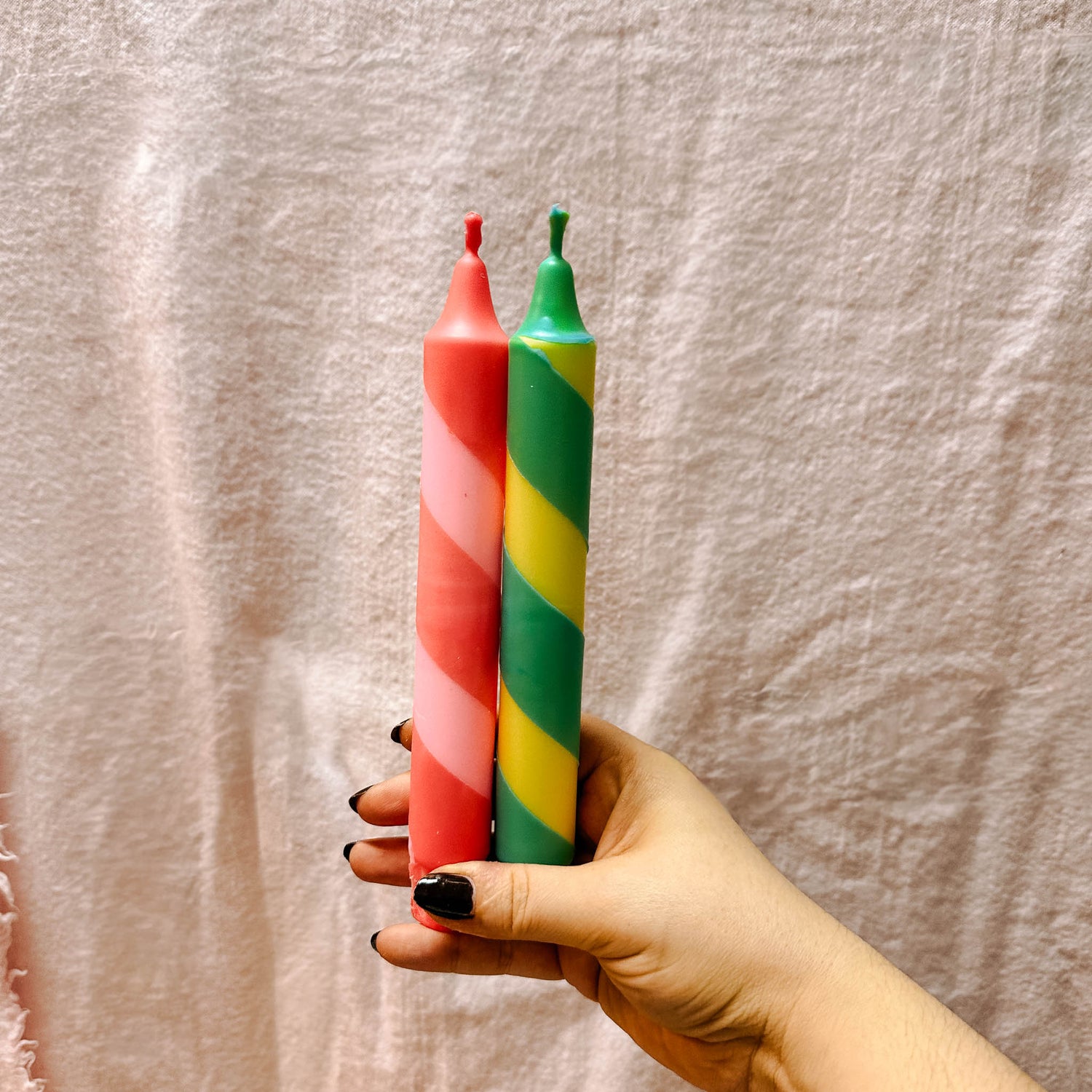 Hände halten und betrachten fertig bemalte Kerzen – buntkerzen selber machen, dip dye kerzen.Auch als Firmenevent buchbar.