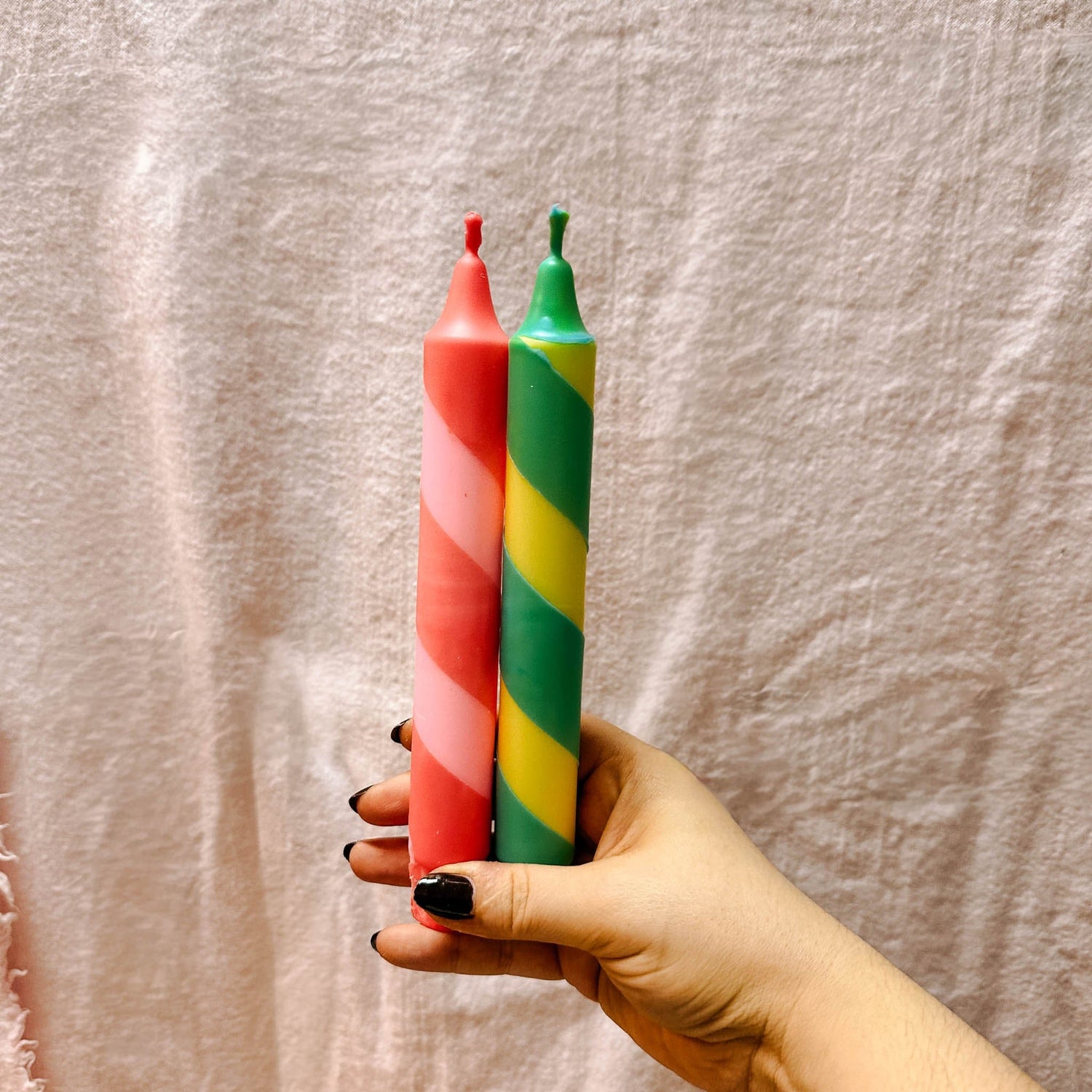 Hände halten und betrachten fertig bemalte Kerzen – buntkerzen selber machen, dip dye kerzen.Auch als Firmenevent buchbar.