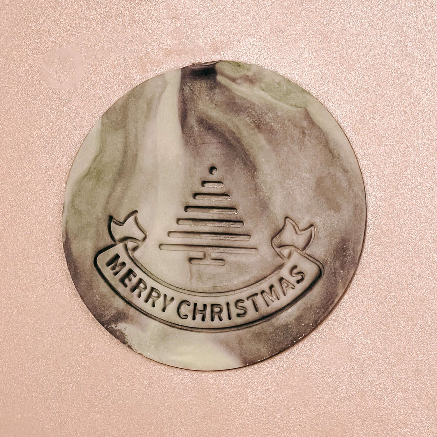 Nahaufnahme eines fondant keks mit „Merry Christmas“-Schriftzug im grauen Farbverlauf – weihnachtskekse ideen berlin.Auch als Firmenevent buchbar.