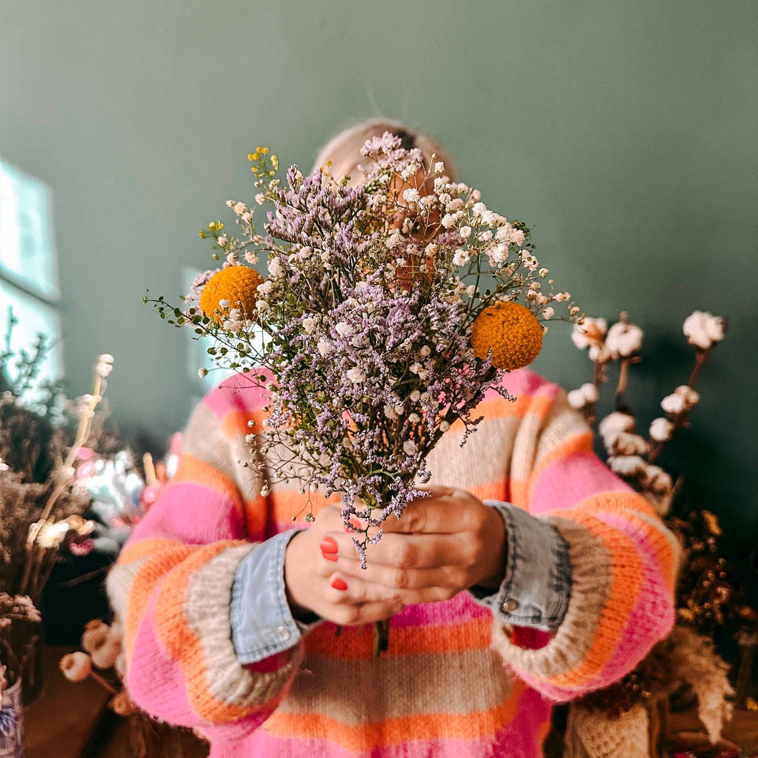 Frau hält bunten Blumenstrauß in die Höhe – frische Blumen aus der limitierten Frühlingsbox.
