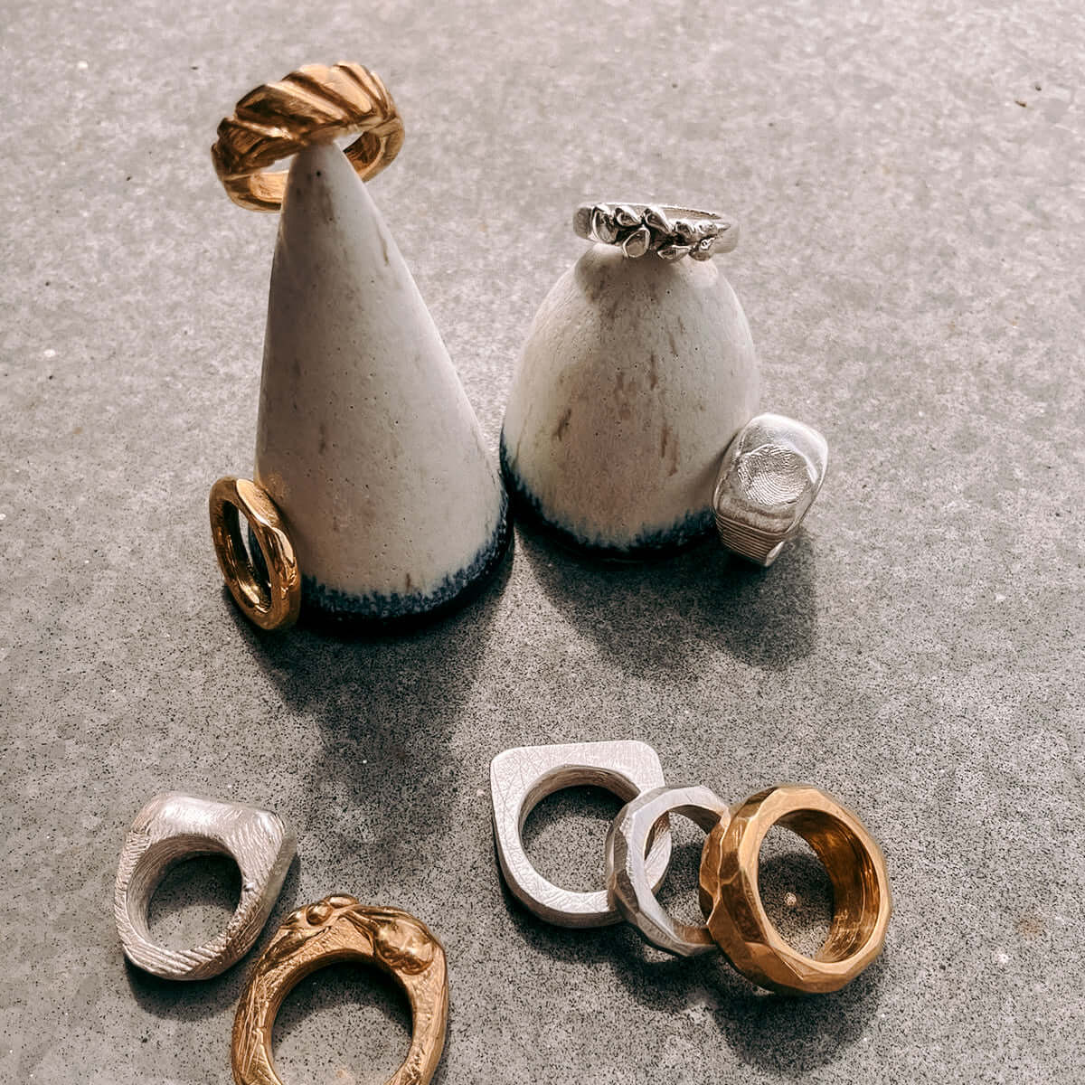 Verschiedene Gold- und Silberringe auf Tisch – DIY Ring Workshop, individuelles Schmuckdesign, Handarbeit.