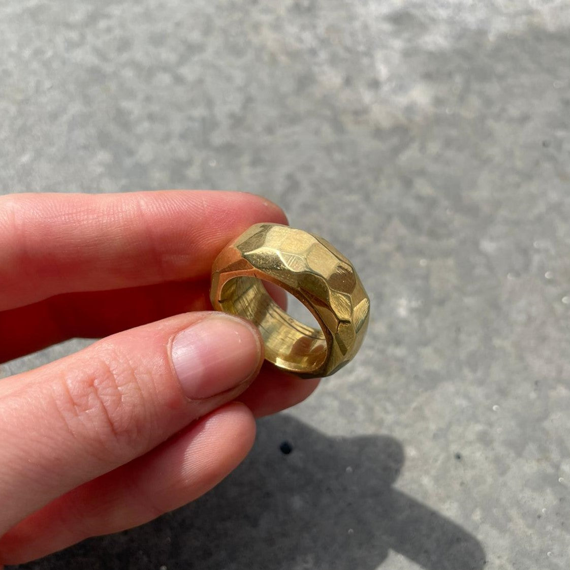 Zwei Finger halten goldenen Ring – DIY Ring Workshop, individuelle Schmuckgestaltung, Goldschmiedekunst.