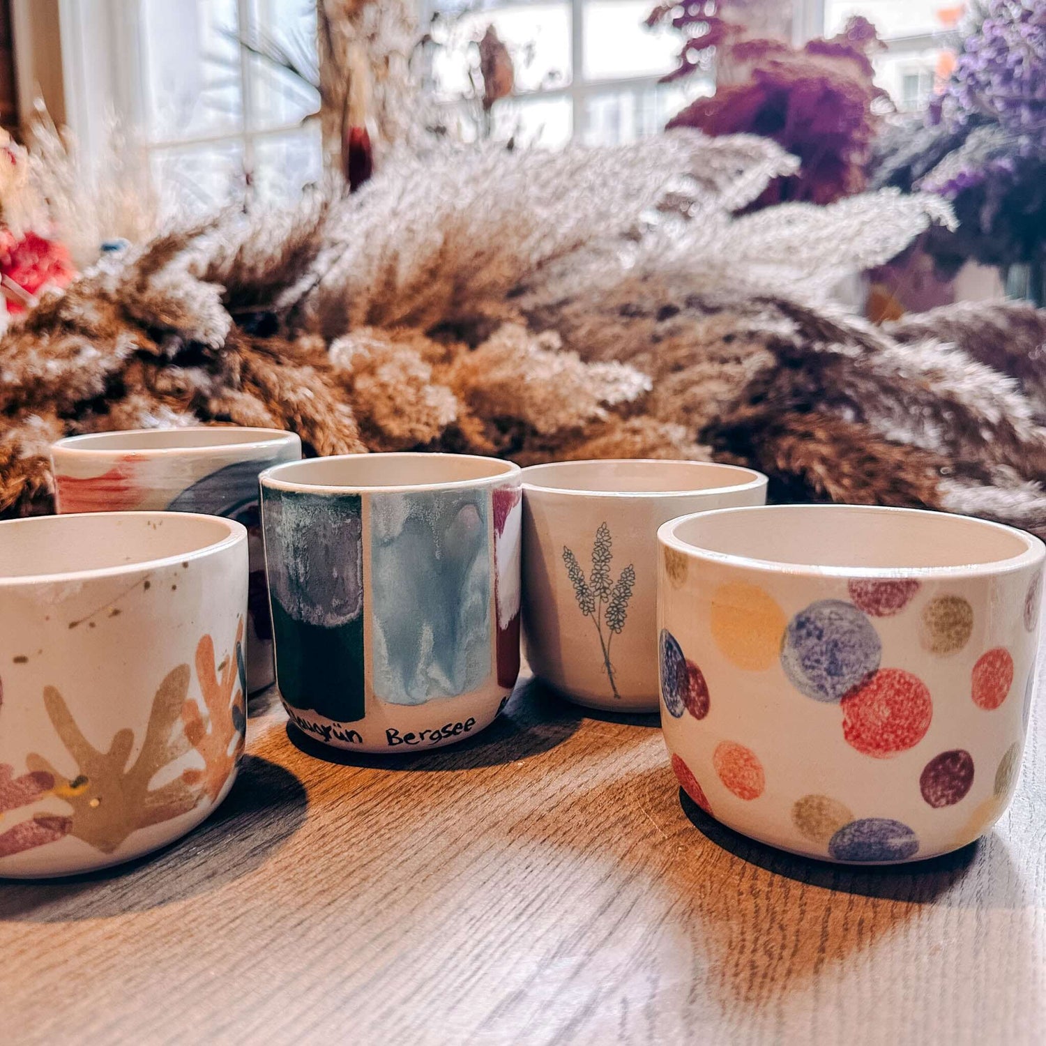 Mehrere Keramikbecher auf Tisch zusammengestellt – DIY Keramik Workshop Berlin, kreativ Keramik bemalen