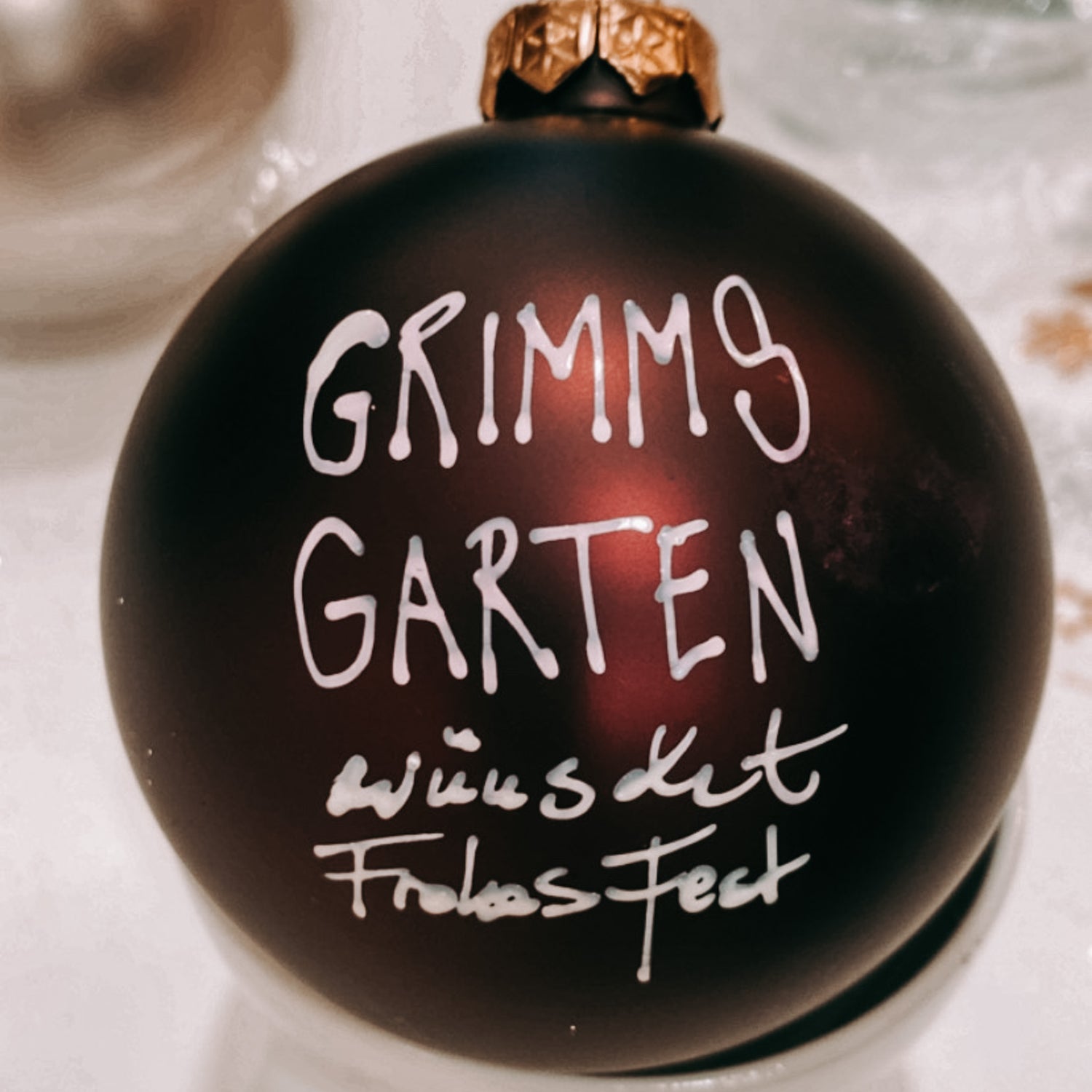 Rote Kugel mit „Grimms Garten wünscht frohes Fest“ – DIY Weihnachtsdeko Teamevent.