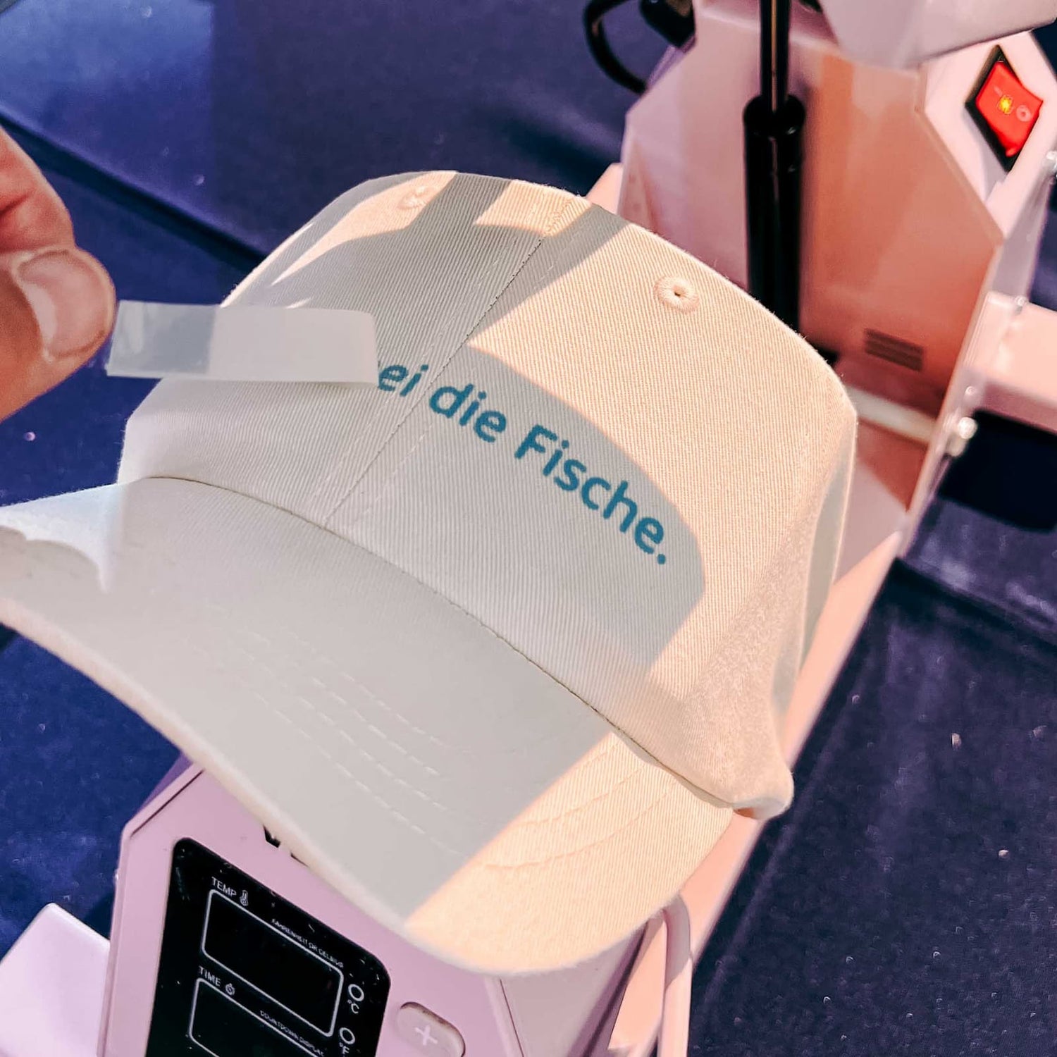 Weiße Cap mit blauer Stickerei beim Caps besticken Workshop als kreatives Teamevent von GRIMMS GARTEN Berlin