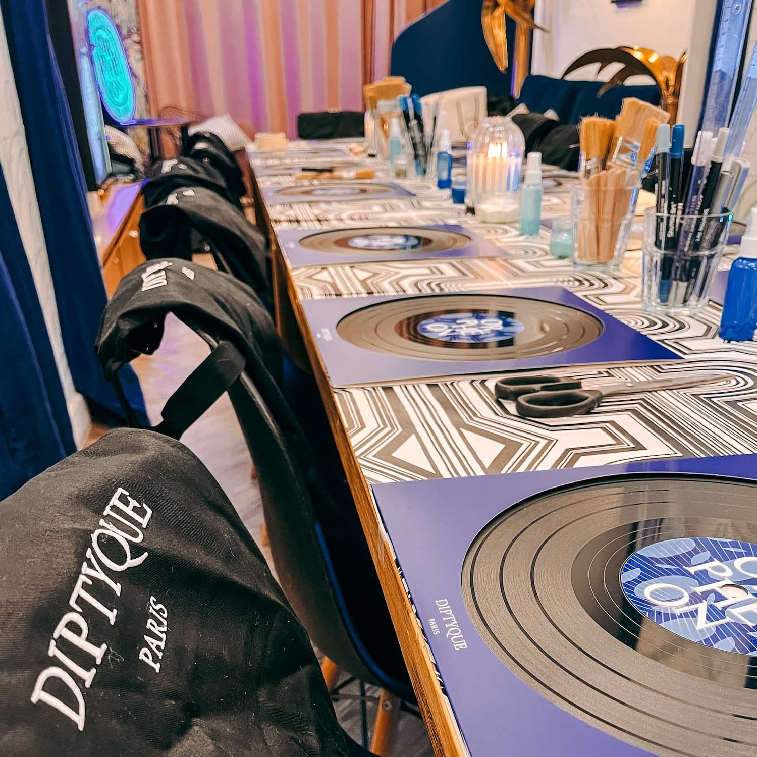 Tisch mit vorbereiteten Arbeitsplätzen, Schallplatten und Materialien beim Vinylplatten bemalen Workshop von GRIMMS GARTEN, Kreativkurs in Berlin