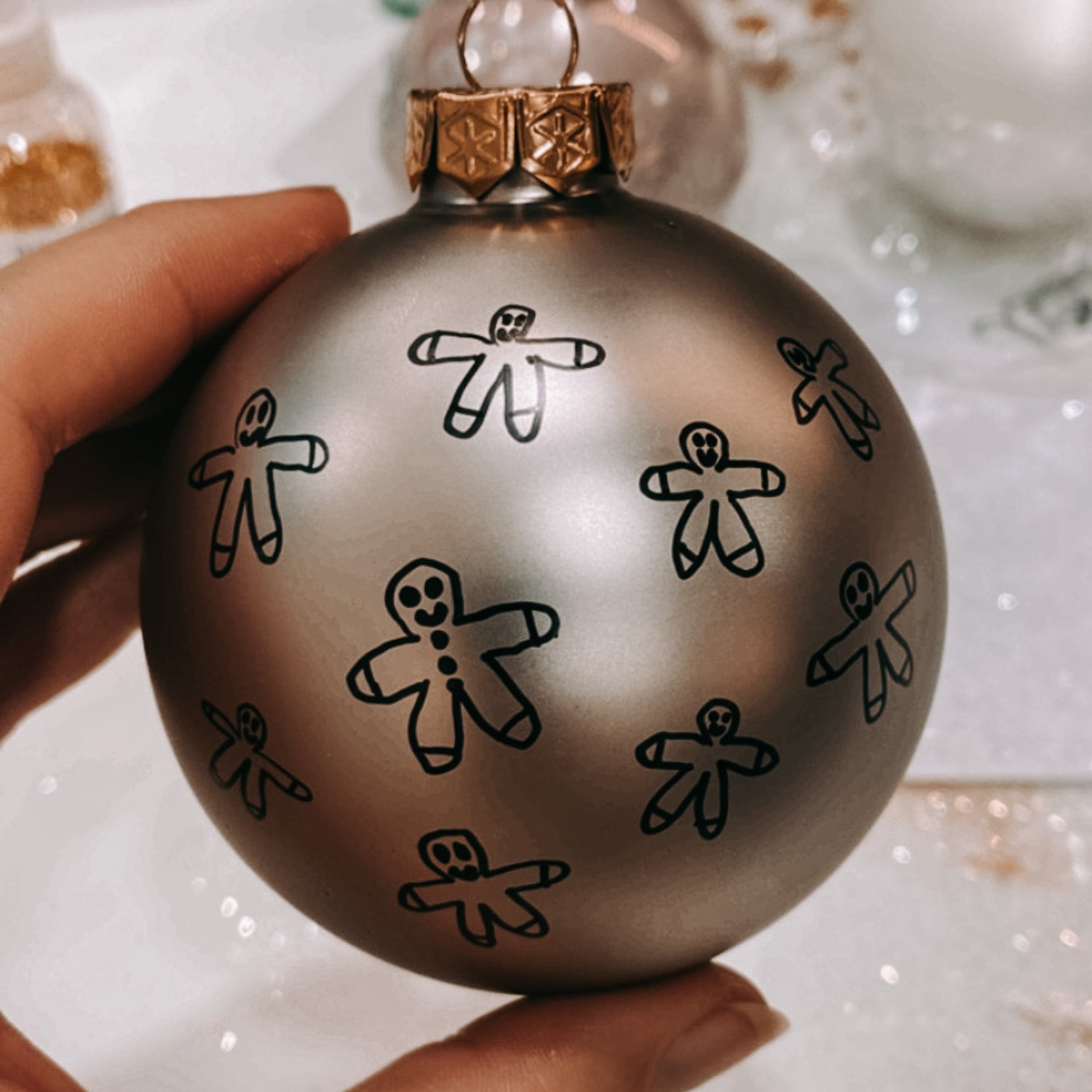Graue Kugel mit bemaltem Lebkuchenmännchen – Weihnachtskugeln individuell gestalten.