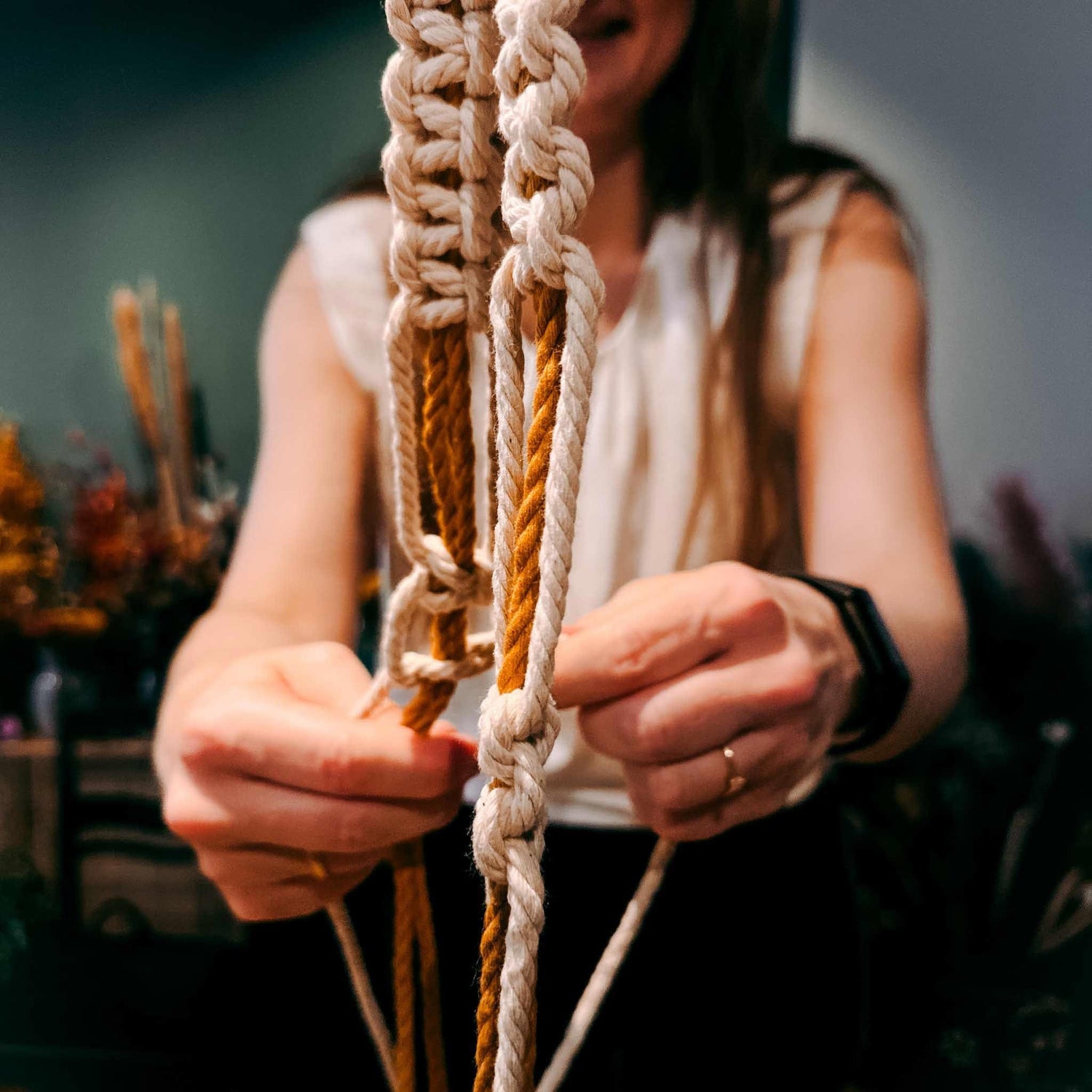 Frau knüpft Makramee-Blumenampel – DIY Makramee Workshop, Handarbeit, Pflanzenampel selbst machen.