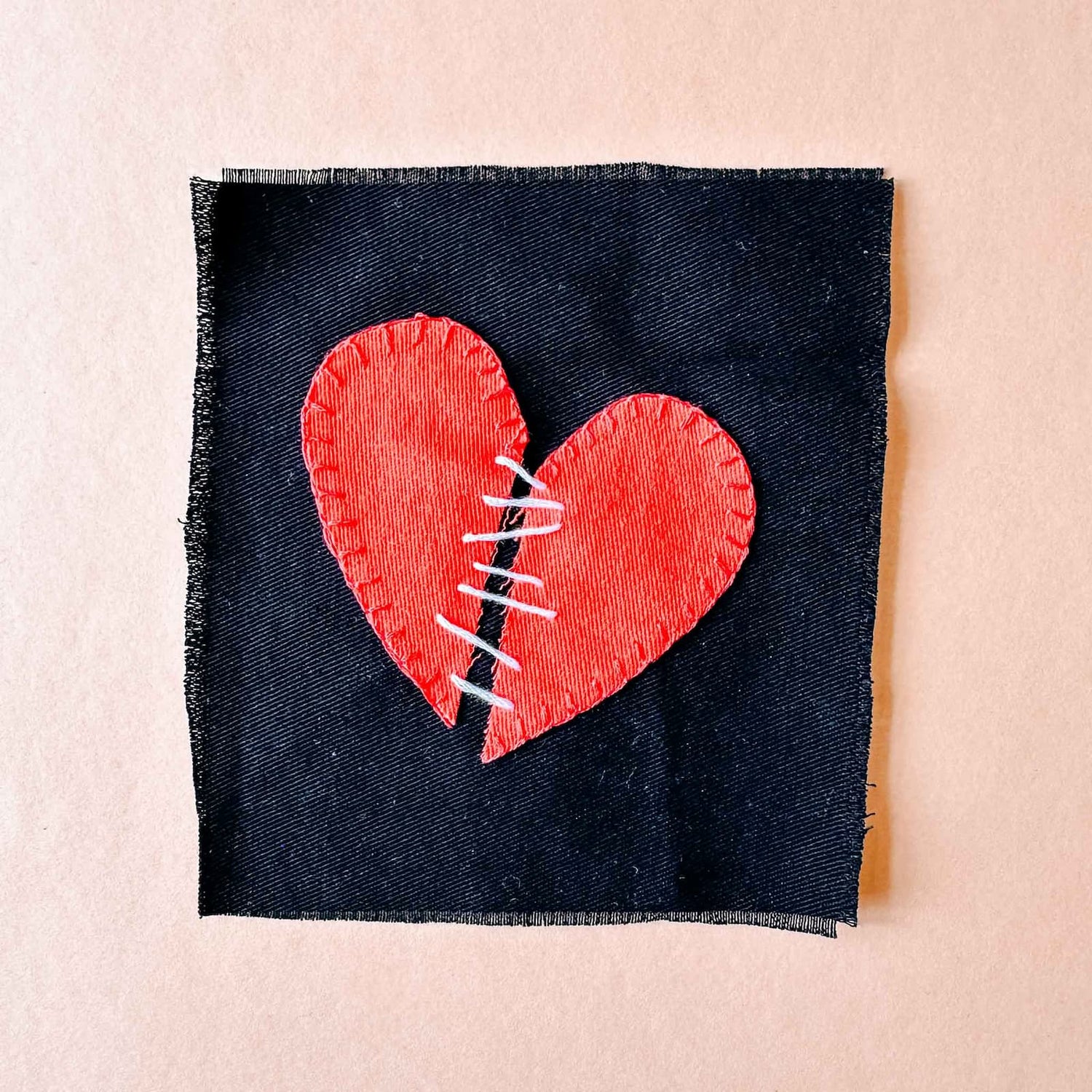 Herz-Patch mit weißen Linien in der Mitte auf schwarzem Stoff beim Patches nähen Workshop von GRIMMS GARTEN, DIY Nähkurs in Berlin