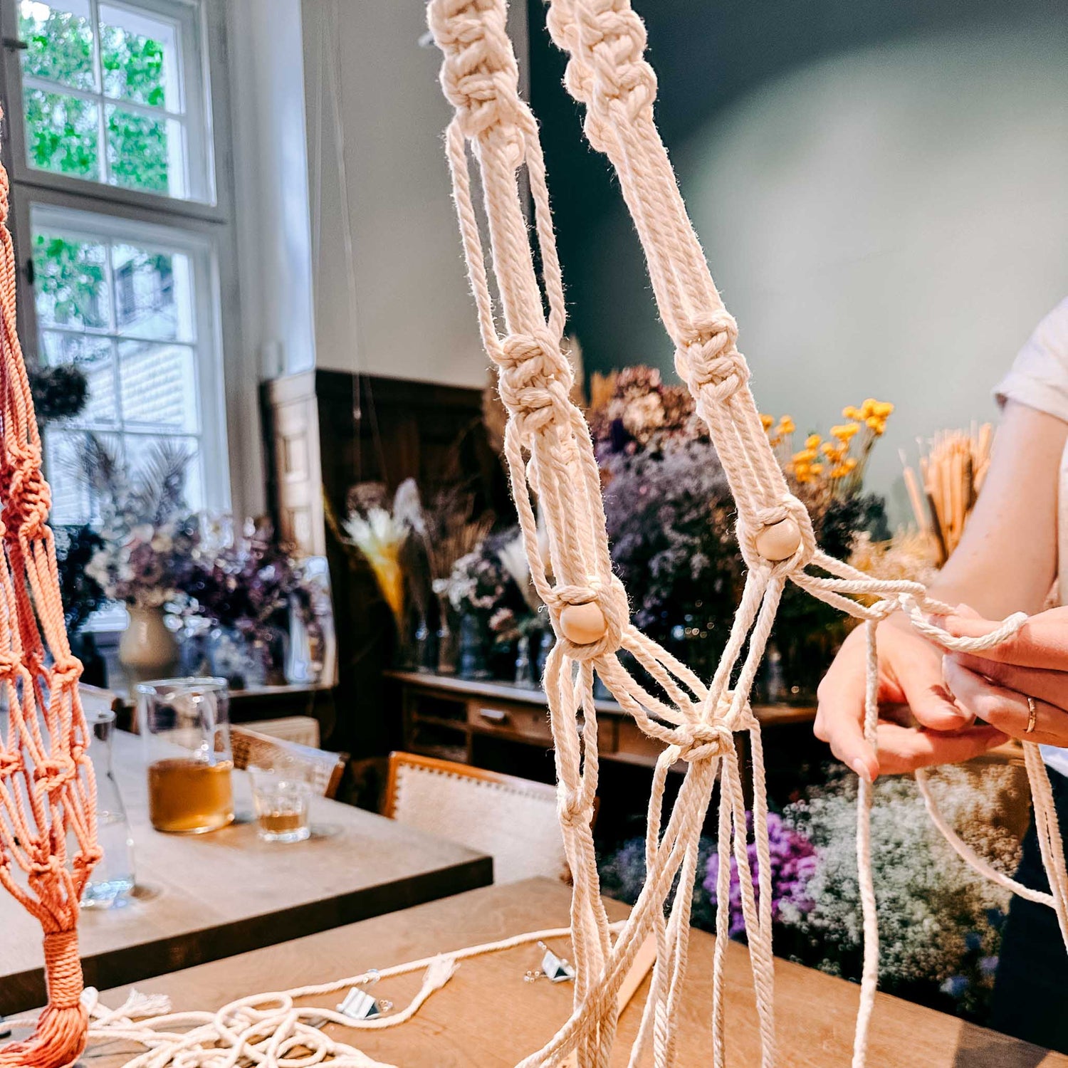 Person flechtet Makramee – DIY Makramee Workshop, Knotenkunst, Blumenampel gestalten.