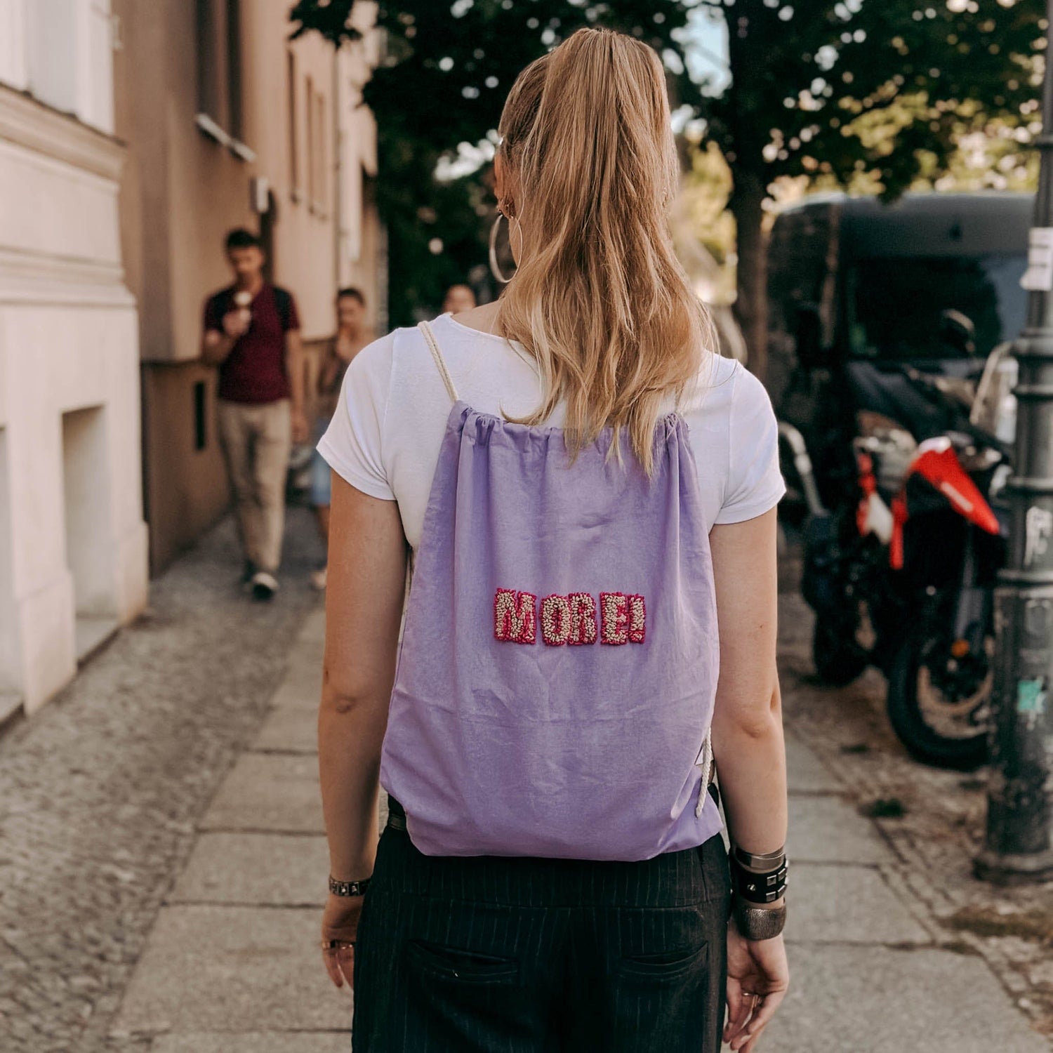 Lilaner Jutebeutel mit Schrift getragen von Person – Punch-Needle Workshop, kreative Wohnaccessoires.