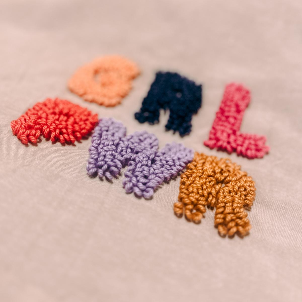 Nahaufnahme „GRLPWR“ in bunten Farben auf Stoff – DIY Punch-Needle Workshop, textile Kunst.