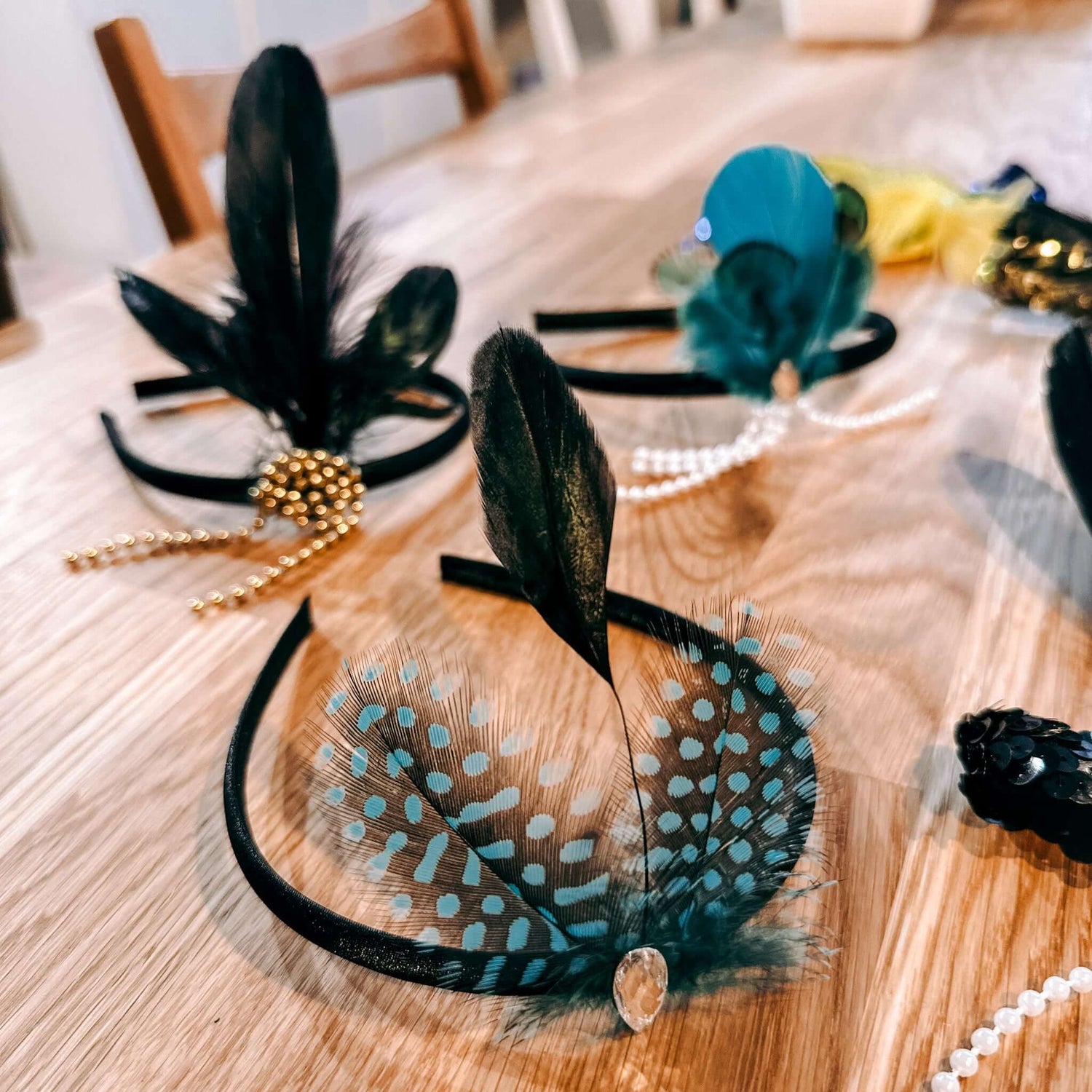 Drei 20er Jahre Haarschmuck-Reifen auf Tisch in verschiedenen Farben – Teamevent oder JGA-Workshop.