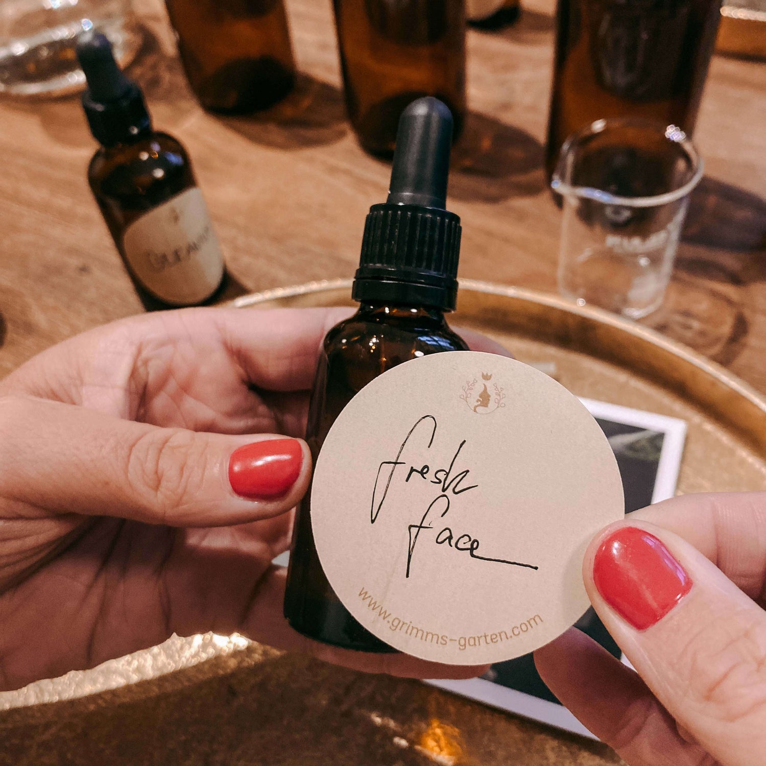 Kleine Flasche mit Label „Fresh Face“ wird von zwei Händen gehalten – bio serum workshop, nachhaltige kosmetik, diy hautpflege.