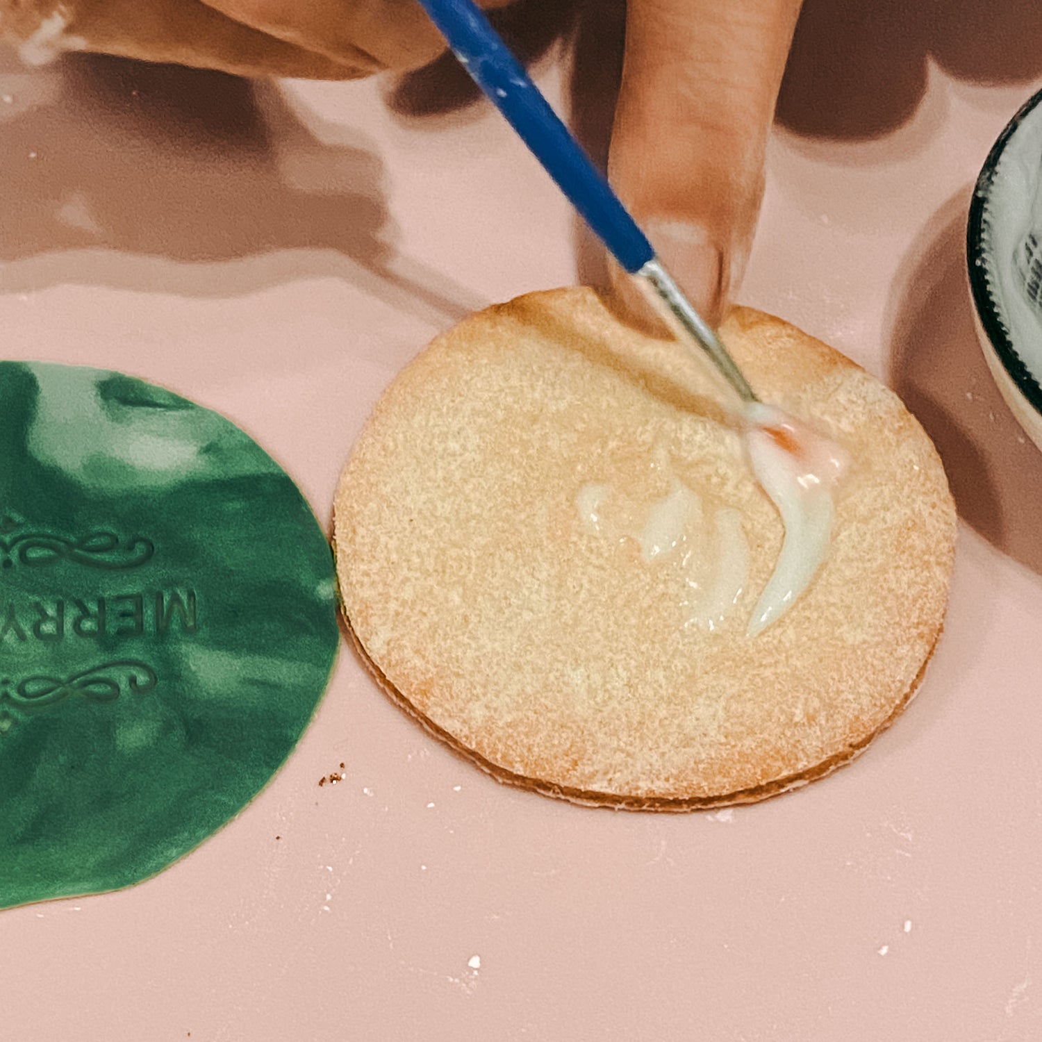 Hände platzieren verzierte kekse auf einem Backblech – fondant kekse selber machen.Auch als Firmenevent buchbar.