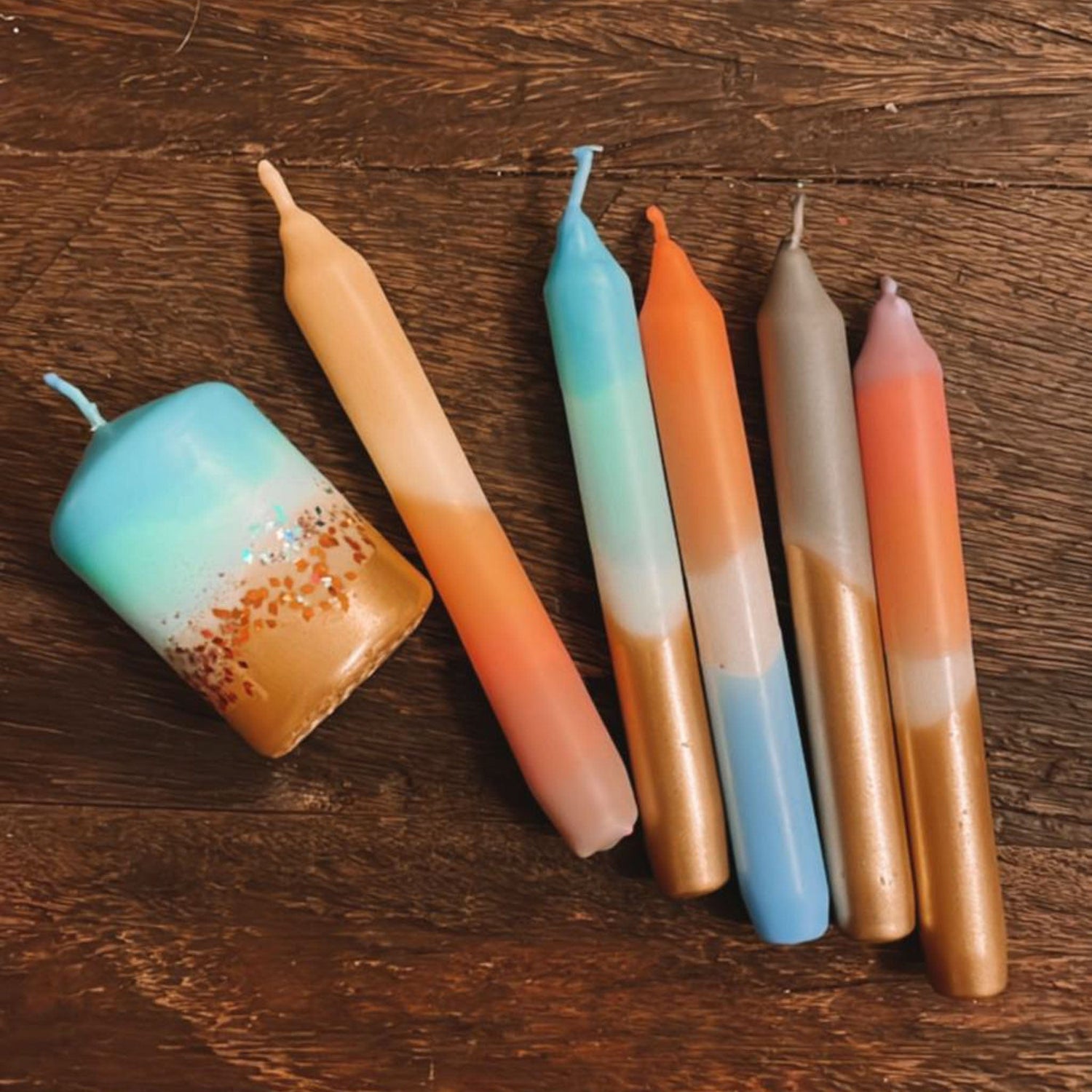 Fünf Kerzen nebeneinander in Orange und Blau – adventskerzen selber machen, buntkerzen.Auch als Firmenevent buchbar.
