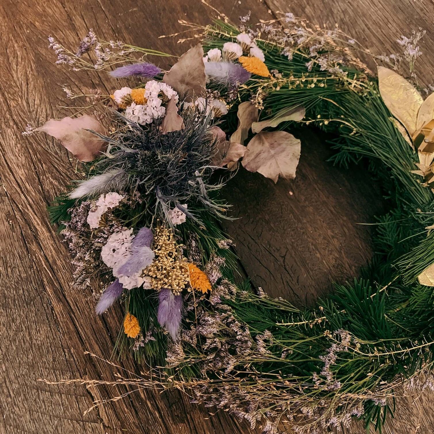 Weihnachtskranz auf Tisch mit lila Akzenten und Kugeln – türkranz weihnachten, weihnachtsdeko, auch für Firmenevents.