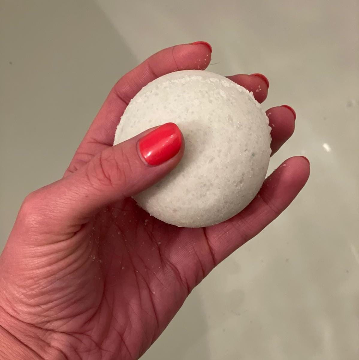 Hand hält vegane Badekugel aus der Wohlfühl Box