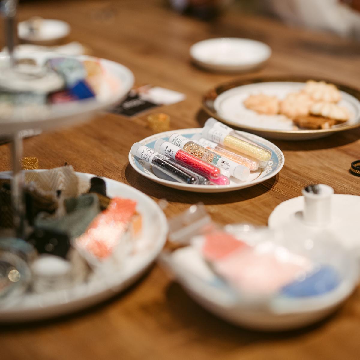 Tisch mit Schalen voller Perlenmaterialien – Perlen Workshop, DIY Schmuck, Miyuki Perlen