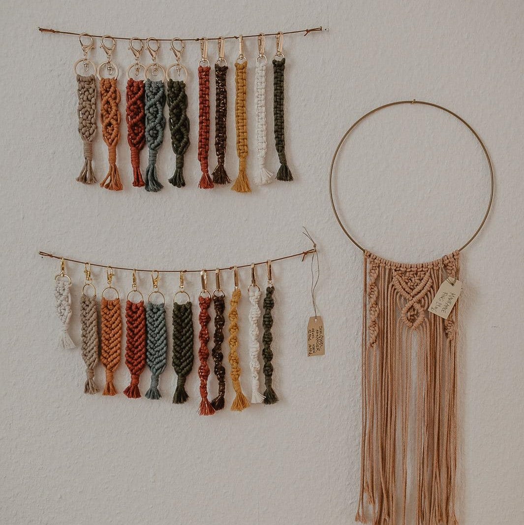 Makramee Schlüsselanhänger an Schnur an Wand hängend, dekoratives Boho-Accessoire.