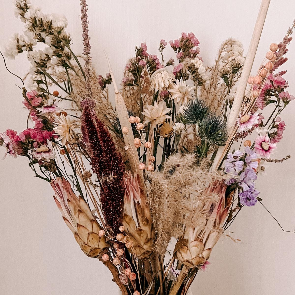 Nahaufnahme Trockenblumenstrauß Frühlingsgefühle, zarte Rosa-, Lila-, Weiß- und Beigetöne für frühlingshafte Dekoration.