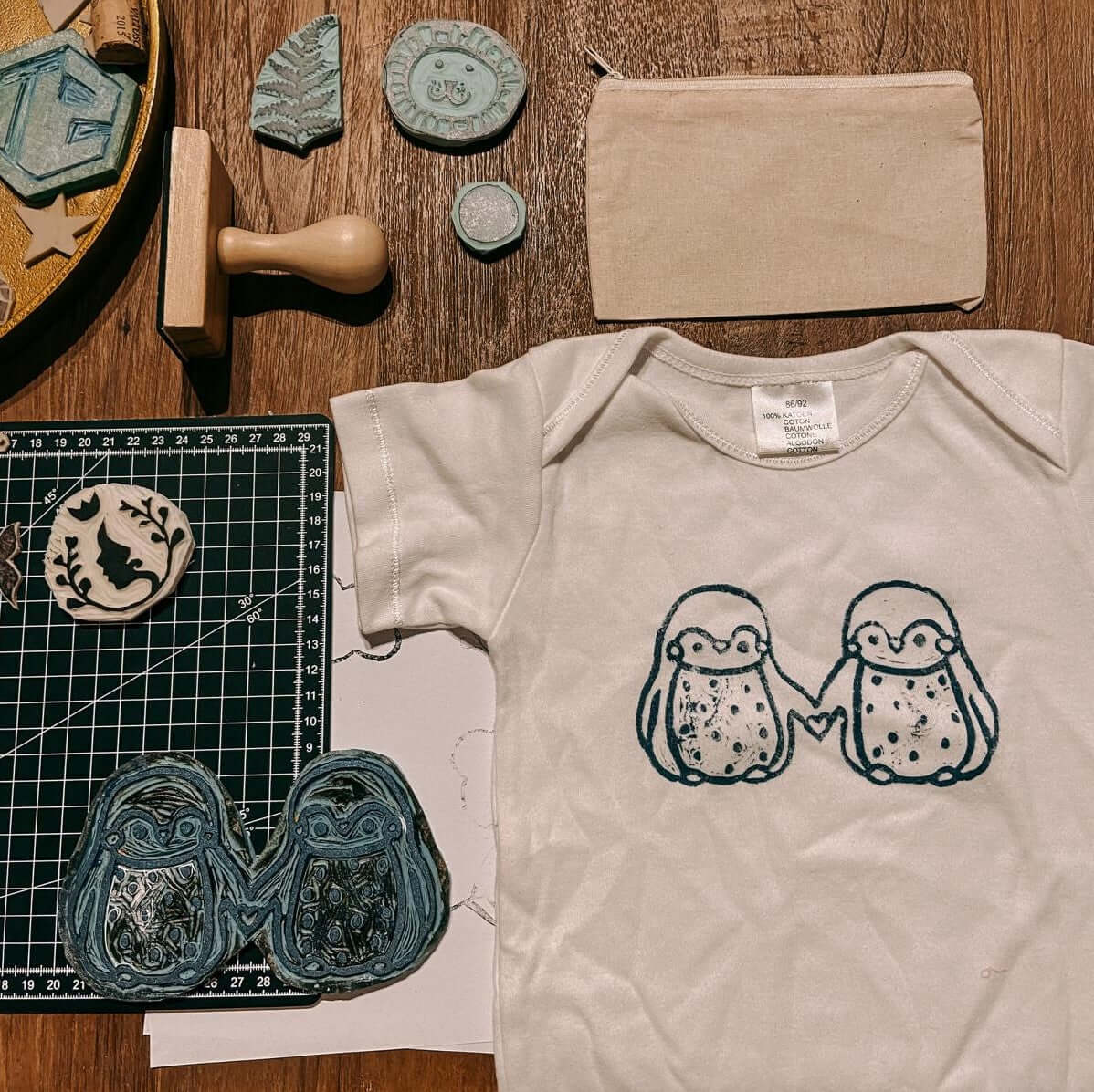 Pinguin-Stempel und Babybody mit zwei Pinguinmotiven – textildruck workshop, stempel design, baby body bedrucken, auch für Firmenevents.