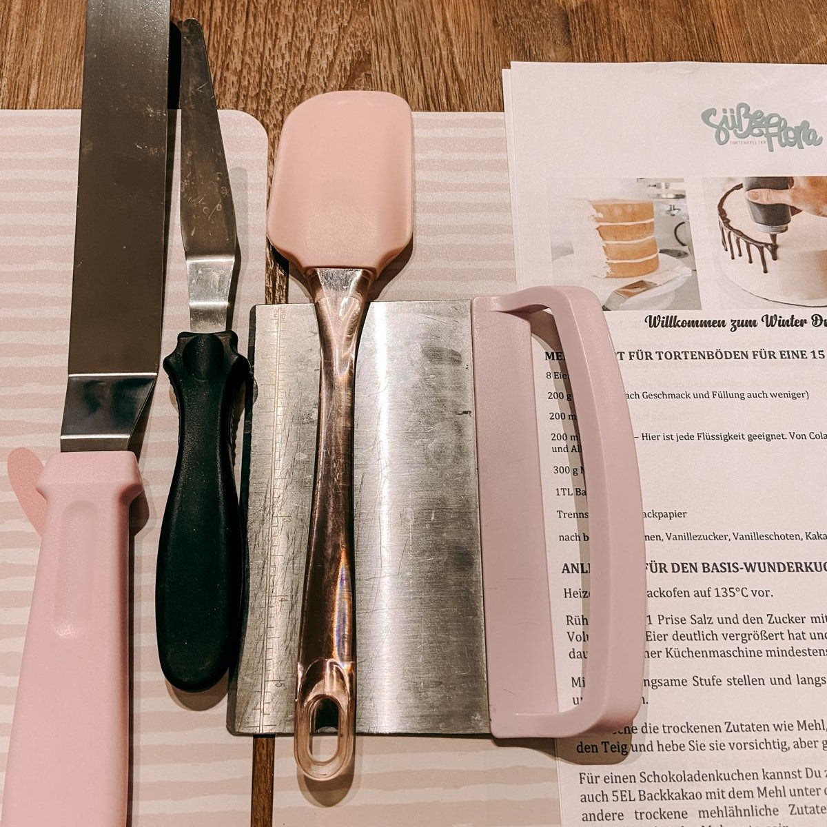 Backwerkzeuge aufgereiht auf Tisch – Mini Drip Cake Workshop Zutaten.