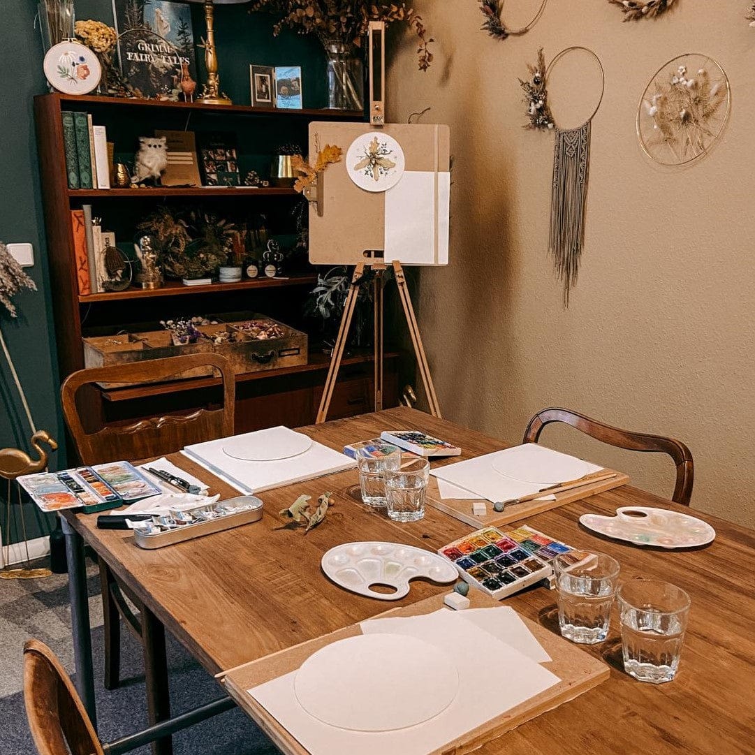 Tisch mit Farben, Pinseln, Paletten und Papier für Aquarell Workshop Herbstmalerei.