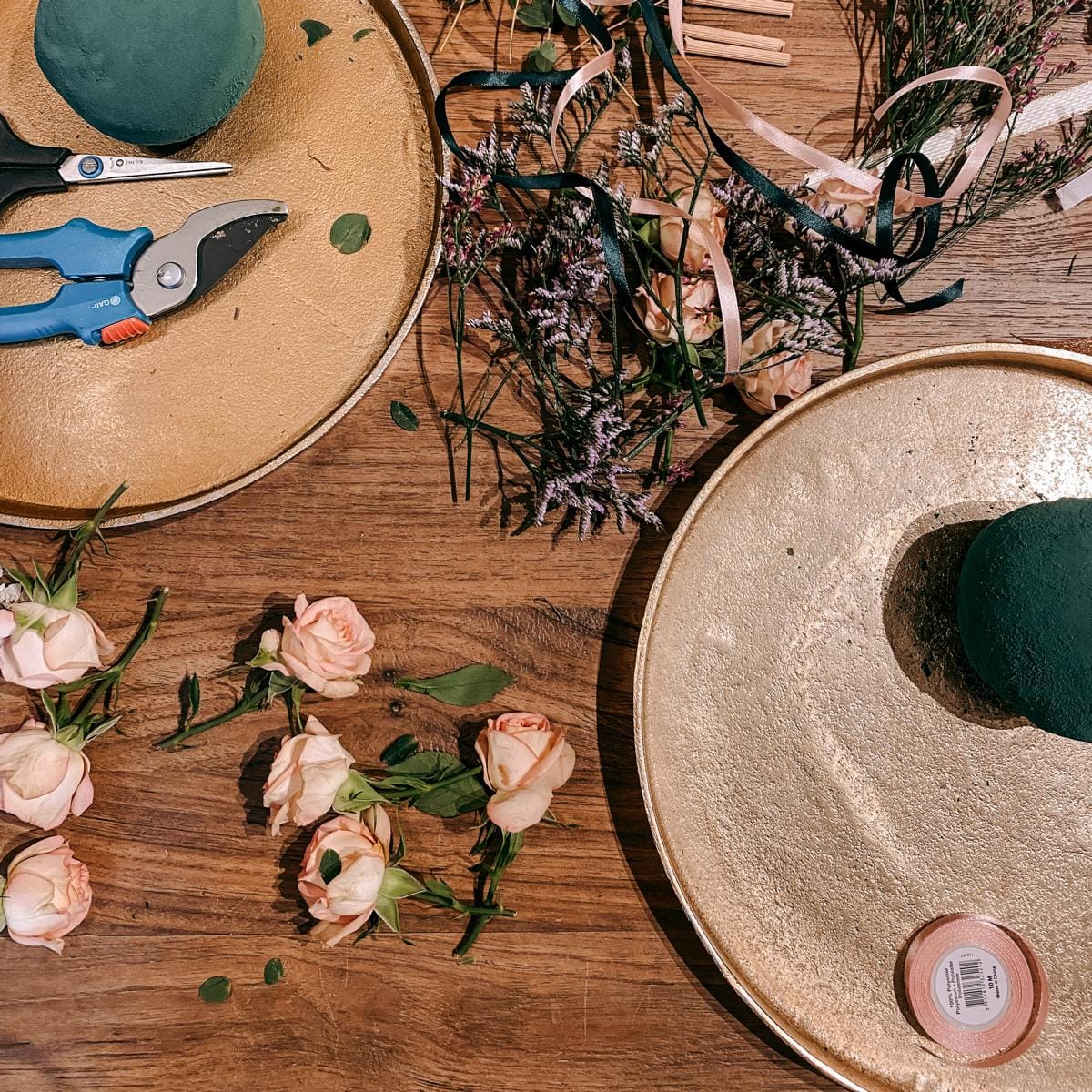 Verschiedenste Blumen und Materialien, rosa Rosen auf Tisch – FlowerBall Workshop